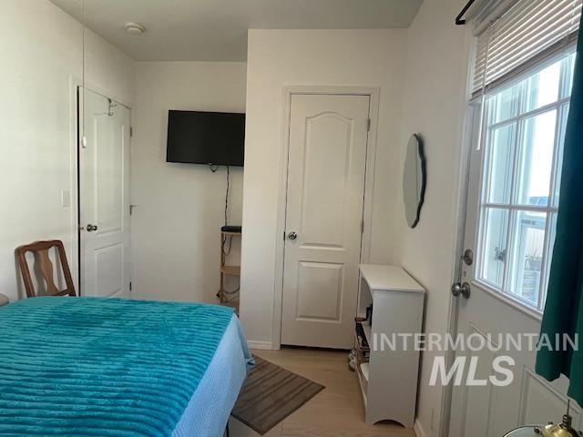 Bedroom with light wood finished floors and baseboards