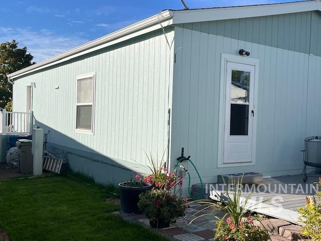 View of side of home featuring a wooden deck and a lawn
