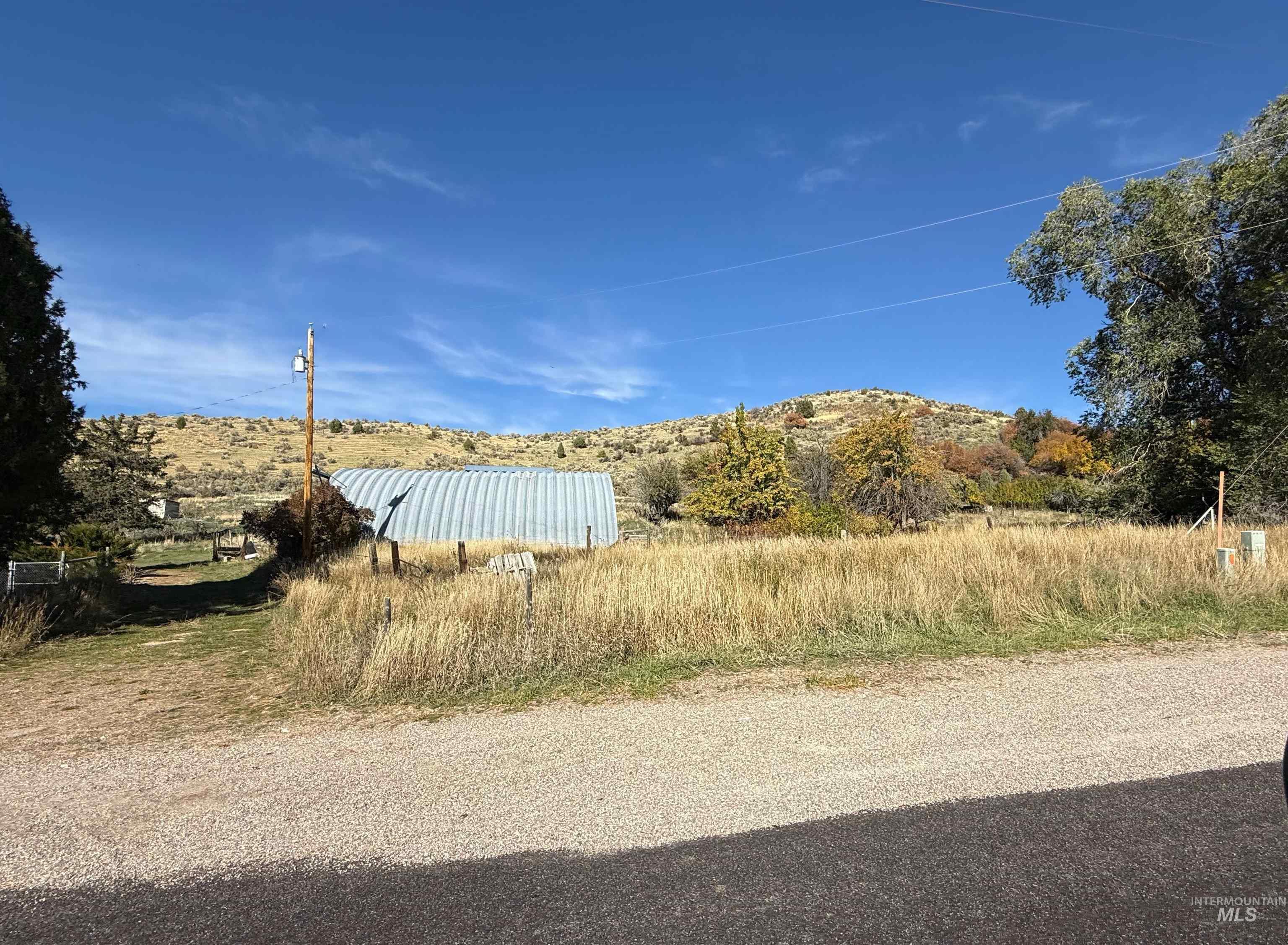 View of asphalt road featuring a mountain view and a view of rural / pastoral area