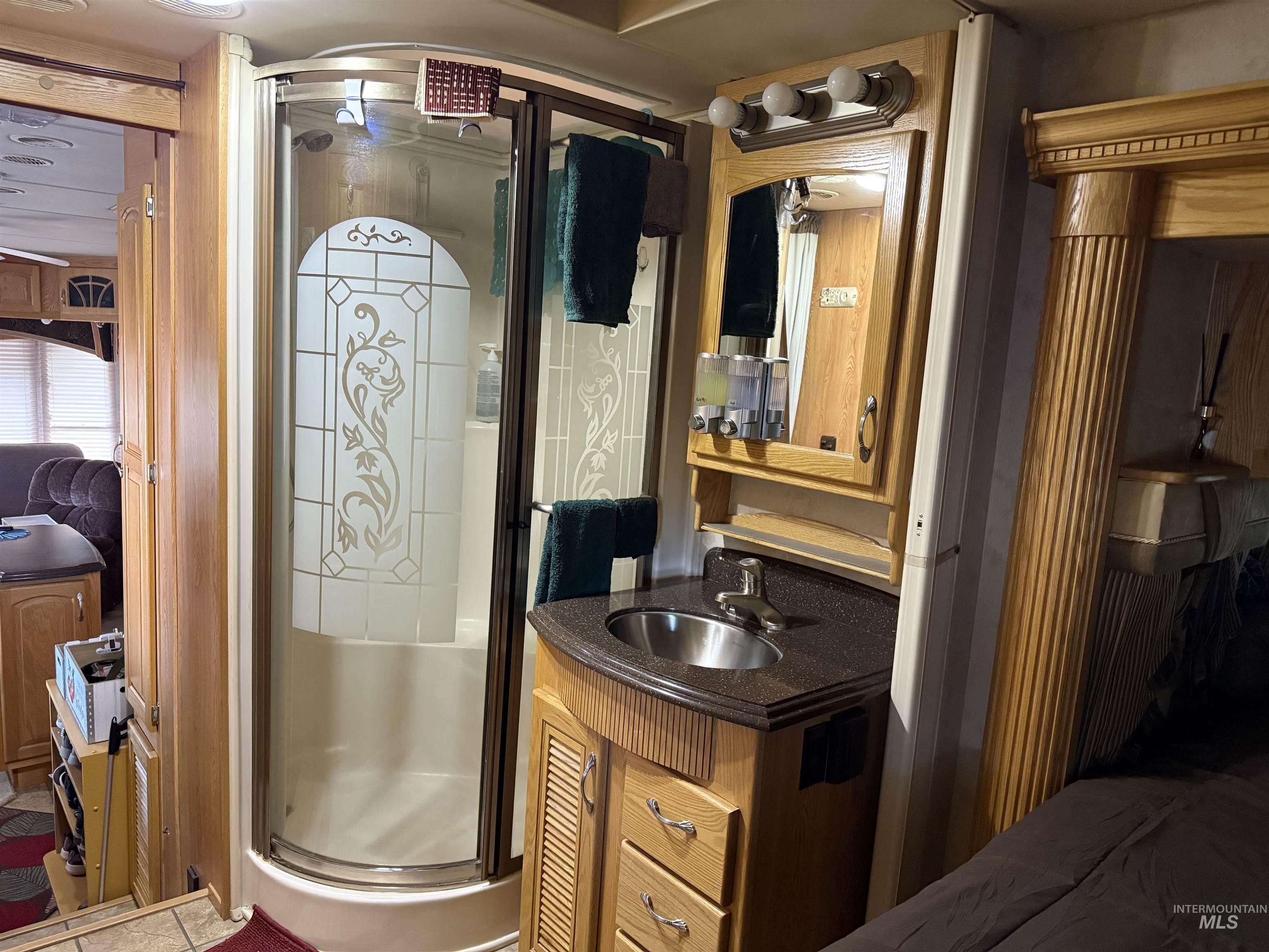 Bathroom featuring vanity, a shower stall