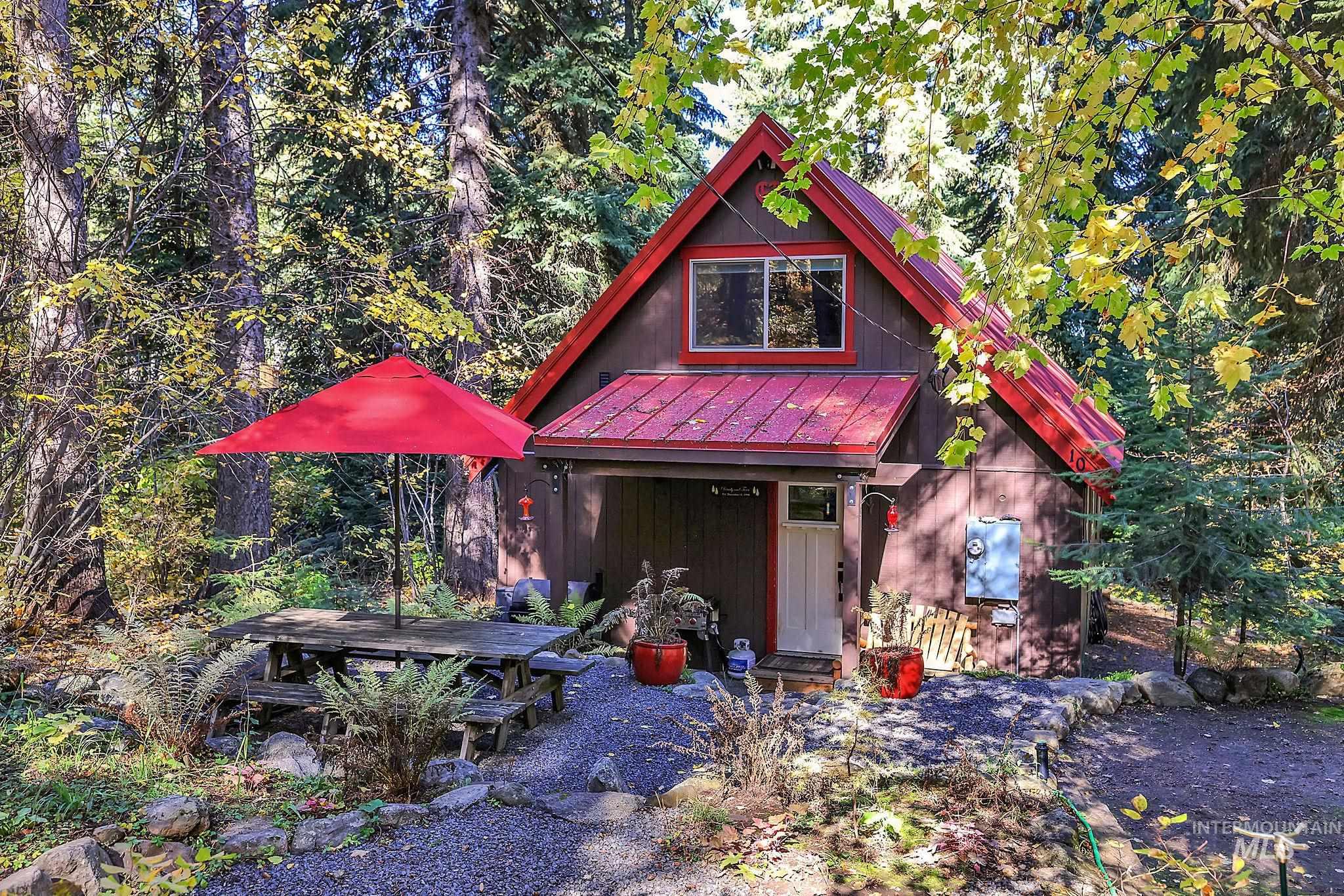 Rustic home featuring a metal roof, a standing seam roof, and a view of trees