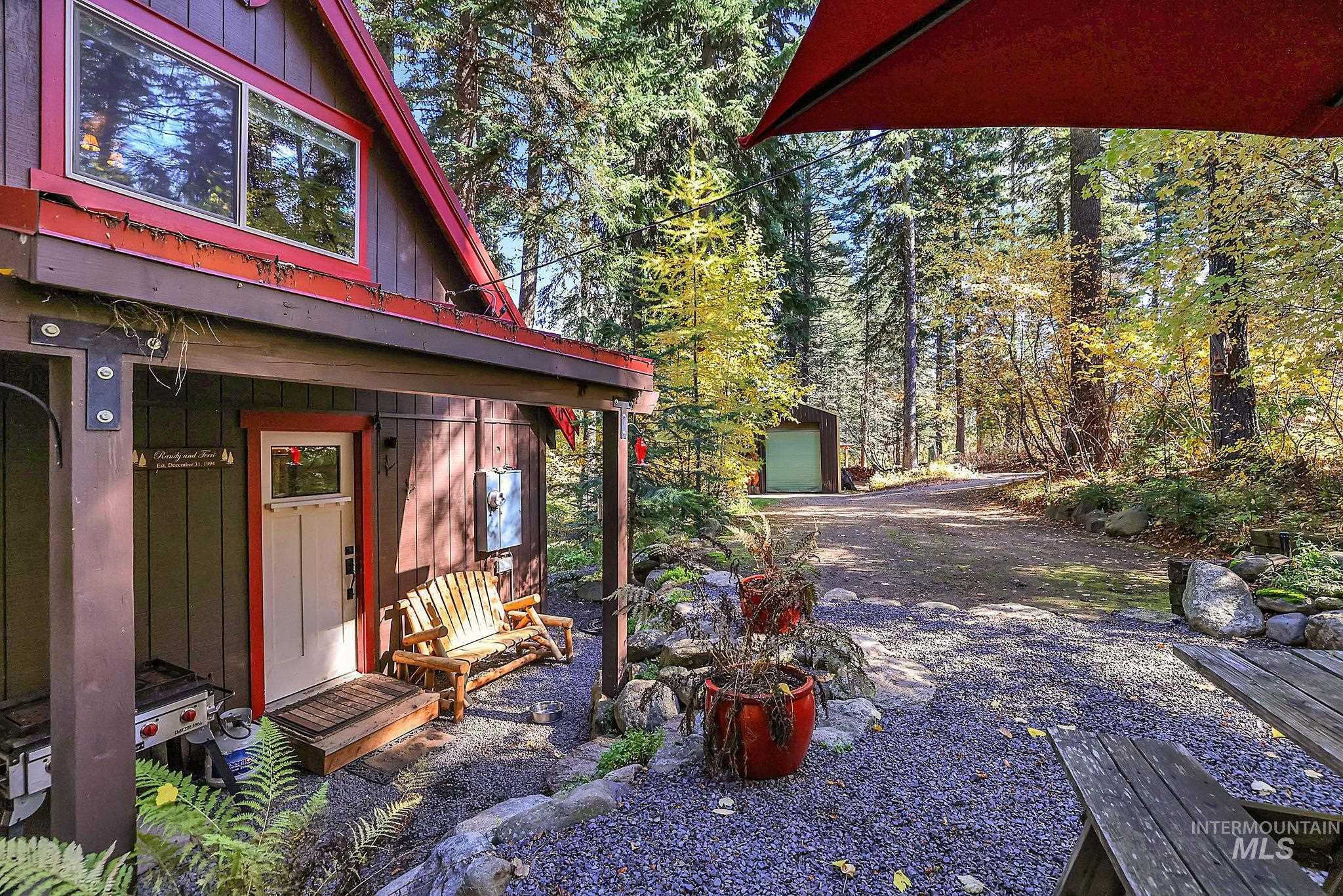 View of yard featuring an outdoor structure, a garage, and a wooded view