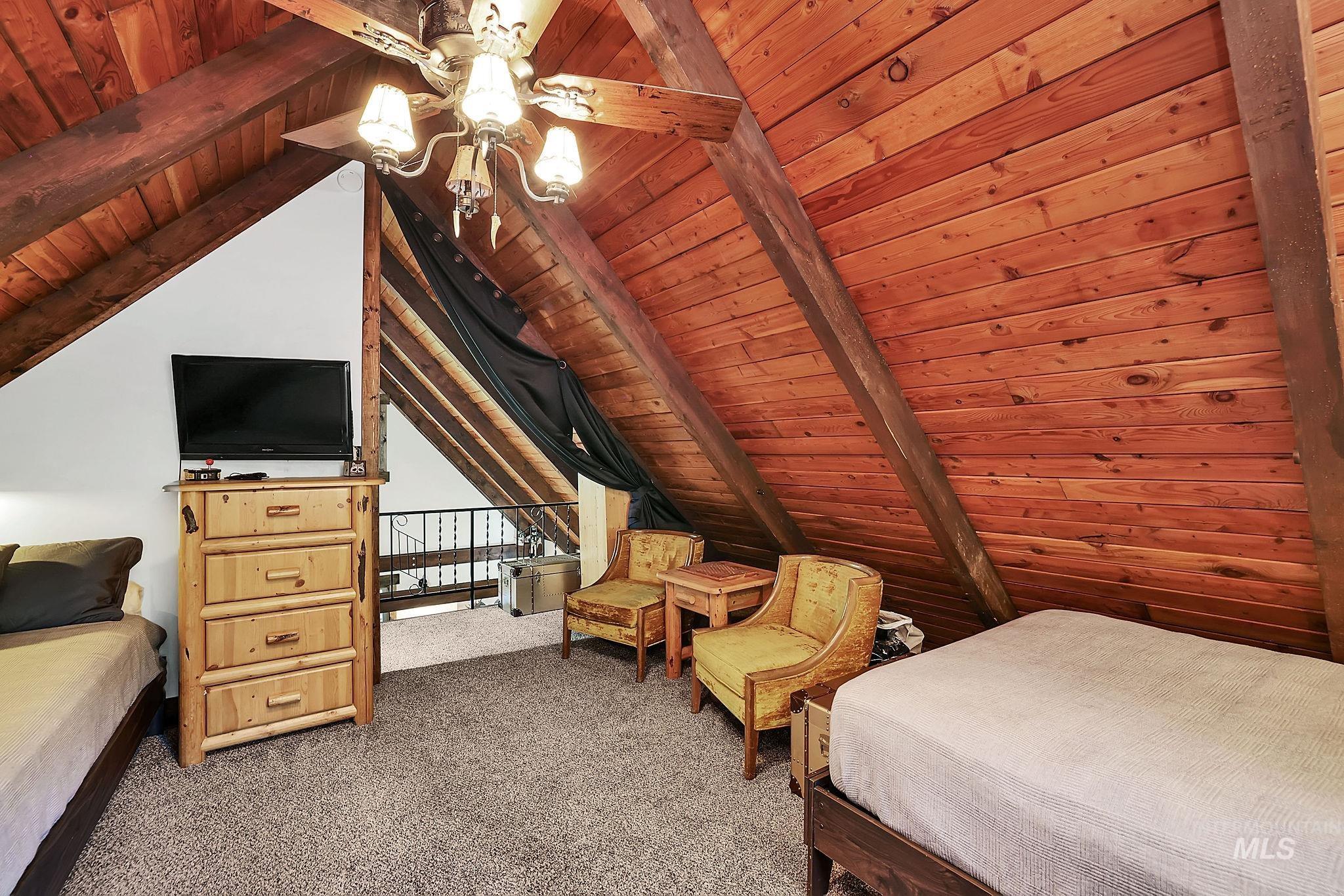 Carpeted bedroom featuring wood ceiling and a ceiling fan