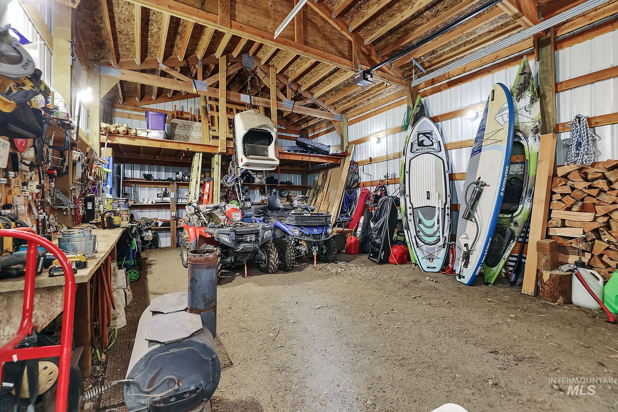 Garage featuring a workshop area, metal wall, and a garage door opener