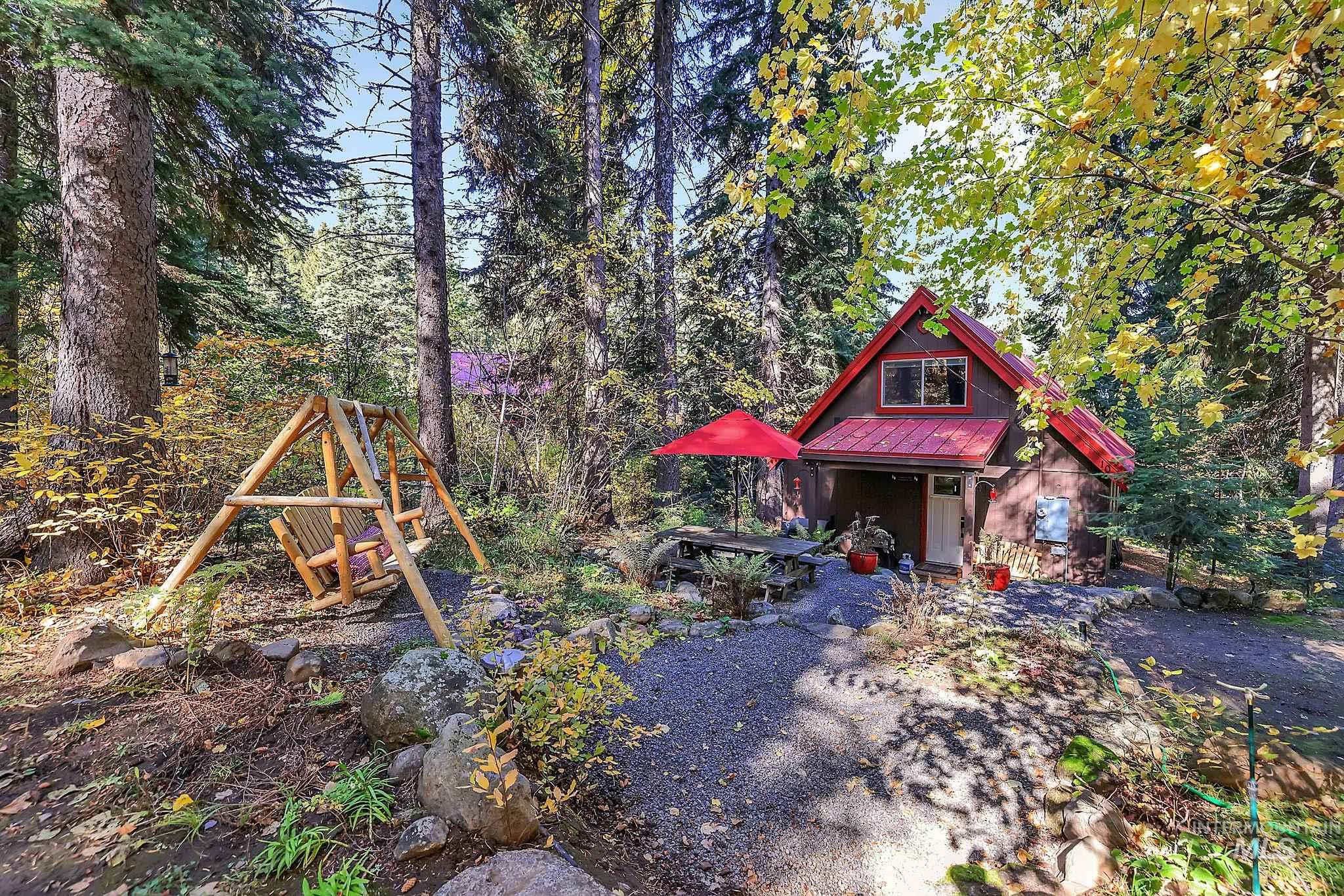 View of yard with an outdoor structure, a porch, and a view of trees