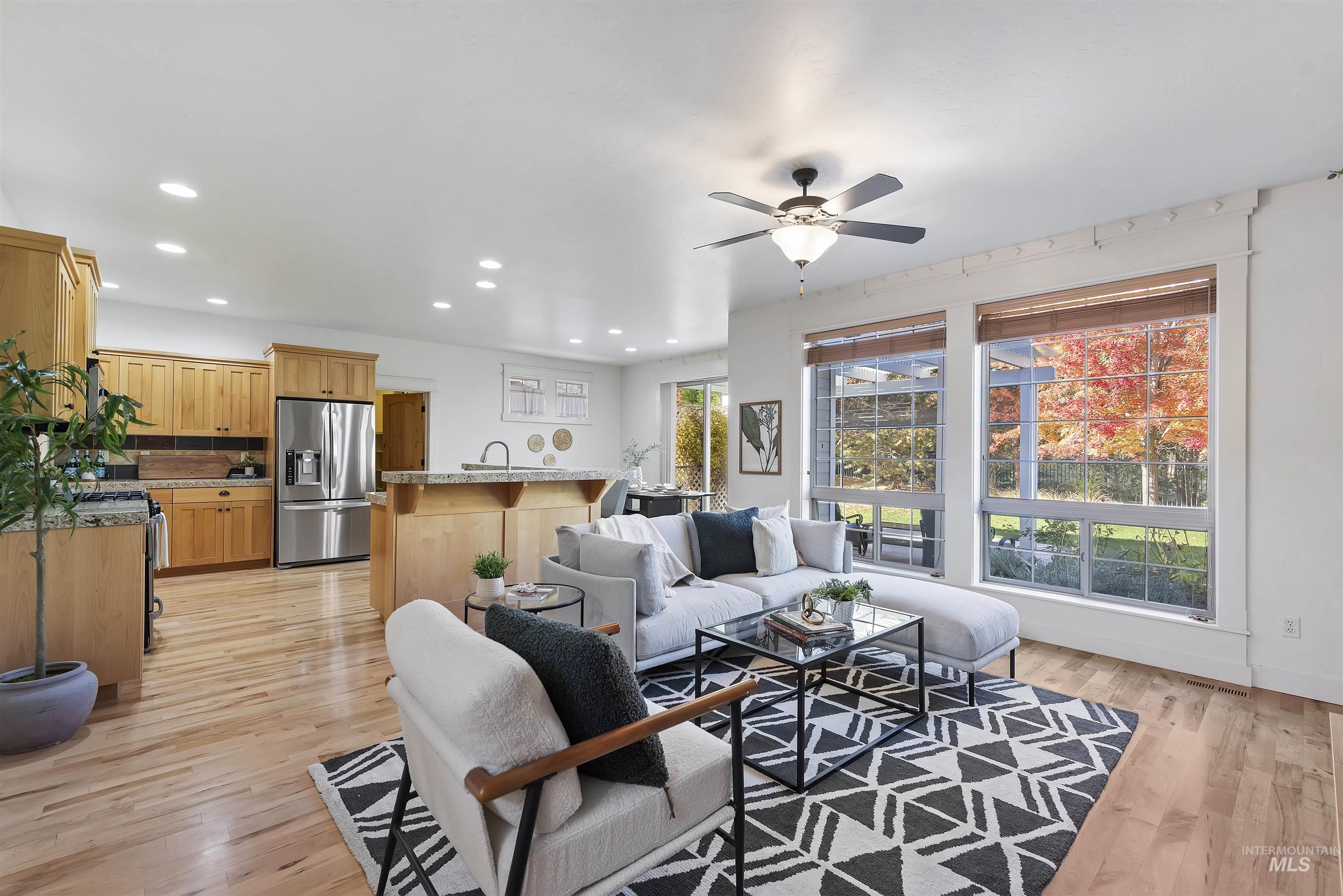 Living room with recessed lighting, light wood-style flooring, and a ceiling fan