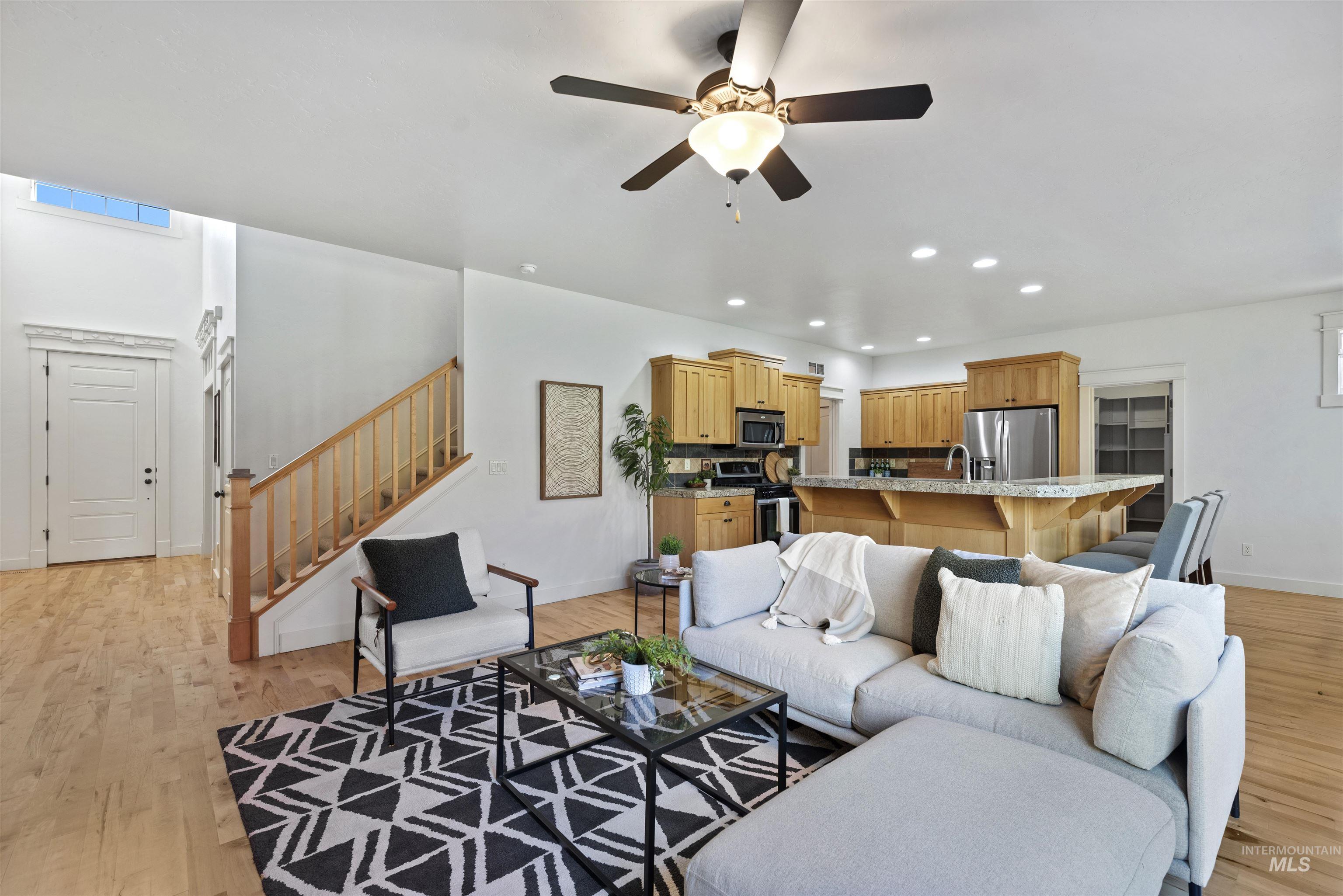 Living area featuring light wood finished floors, recessed lighting, stairway, and a ceiling fan