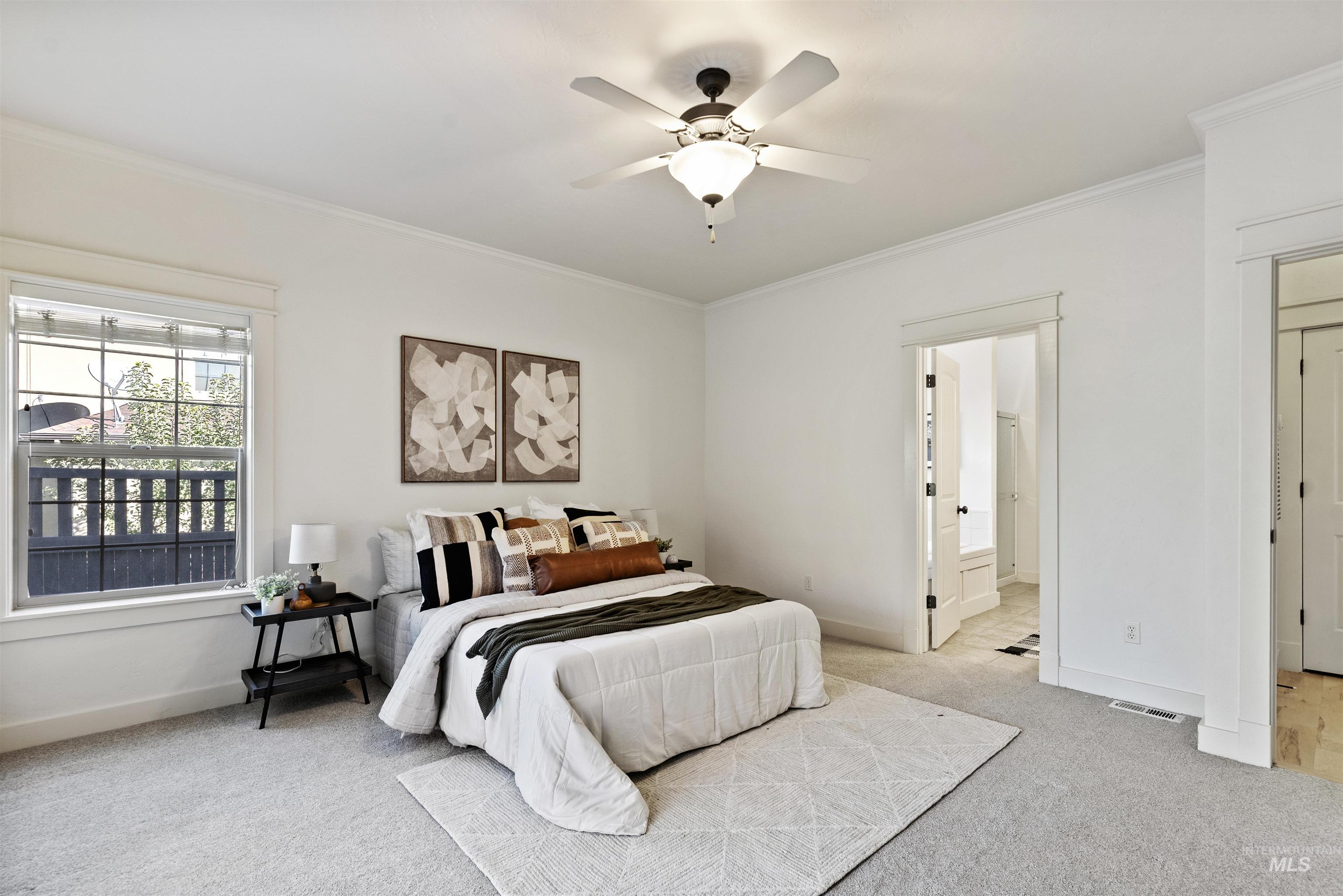 Carpeted bedroom featuring ornamental molding, ceiling fan, and connected bathroom