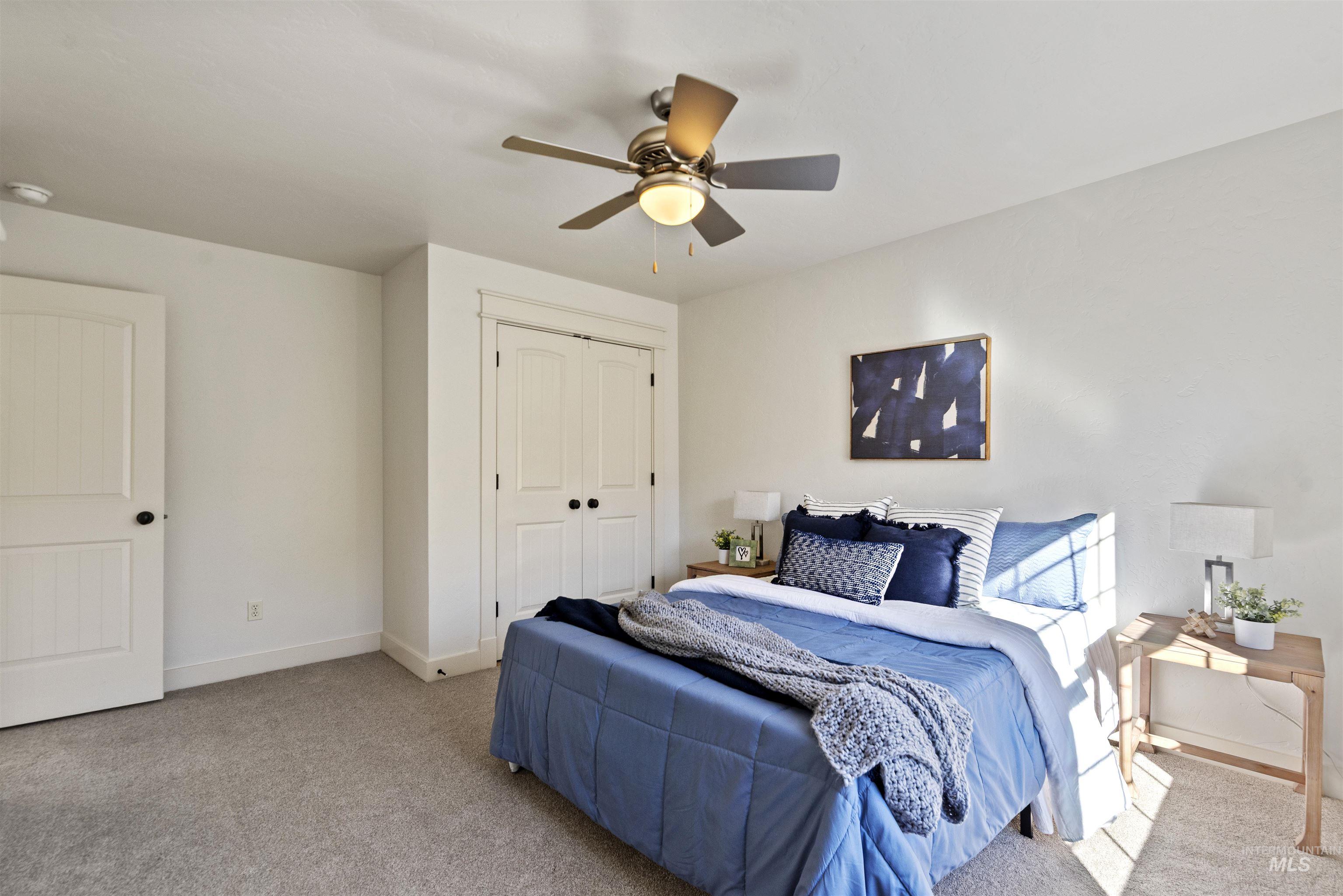 Carpeted bedroom featuring a closet and ceiling fan