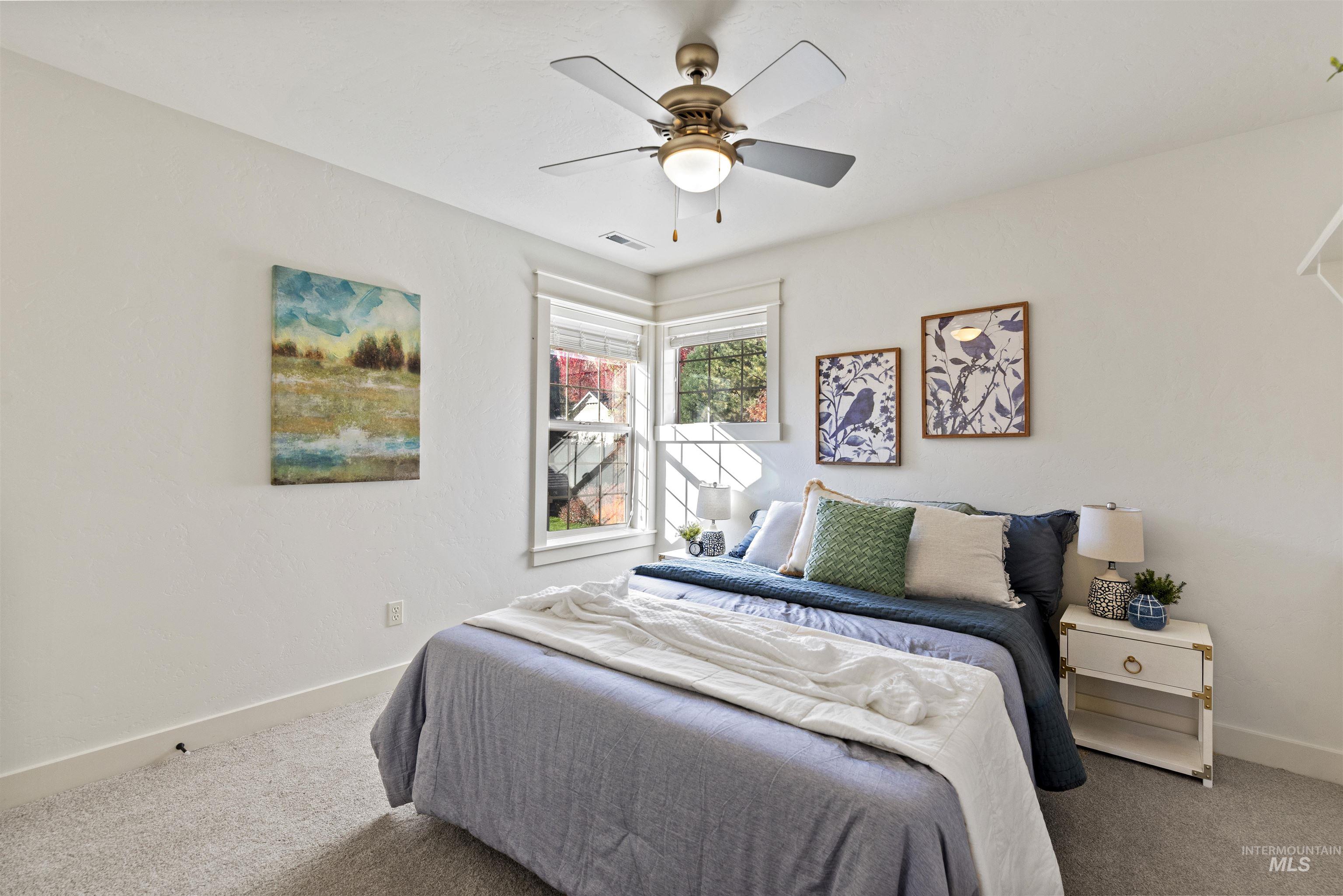 Carpeted bedroom featuring baseboards and ceiling fan