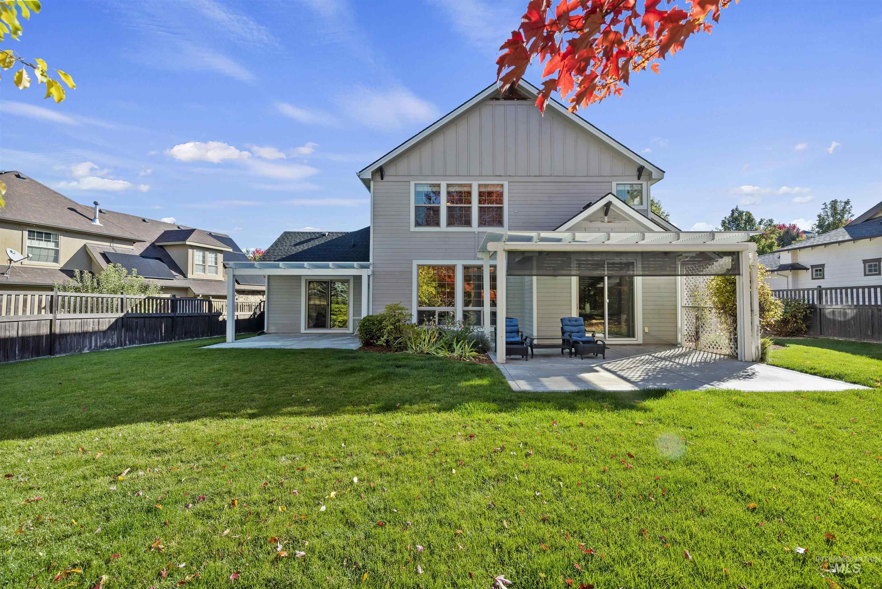 Back of house featuring a patio, a fenced backyard, and board and batten siding