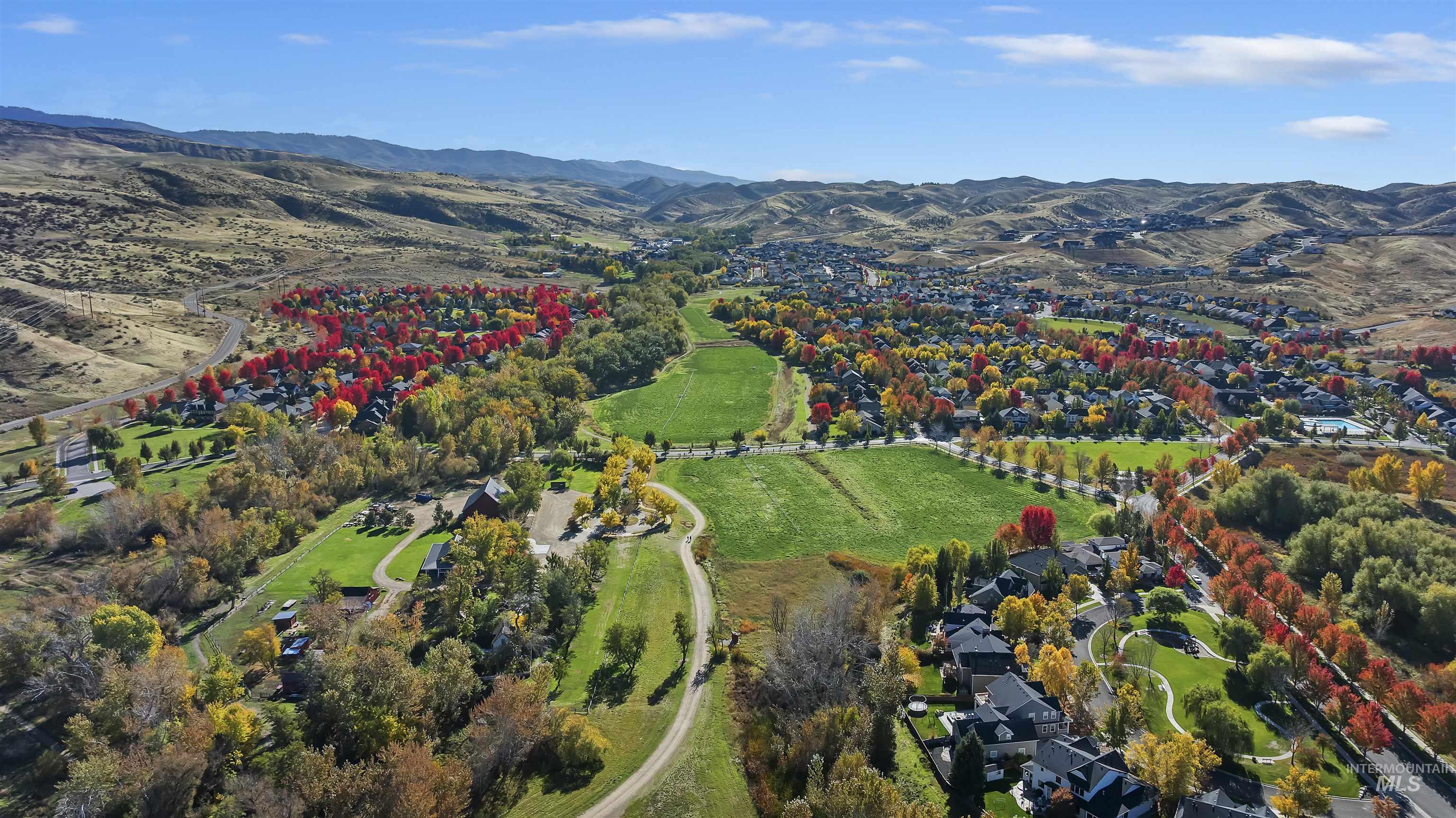Aerial overview of property's location featuring a mountainous background, nearby suburban area, and rural landscape