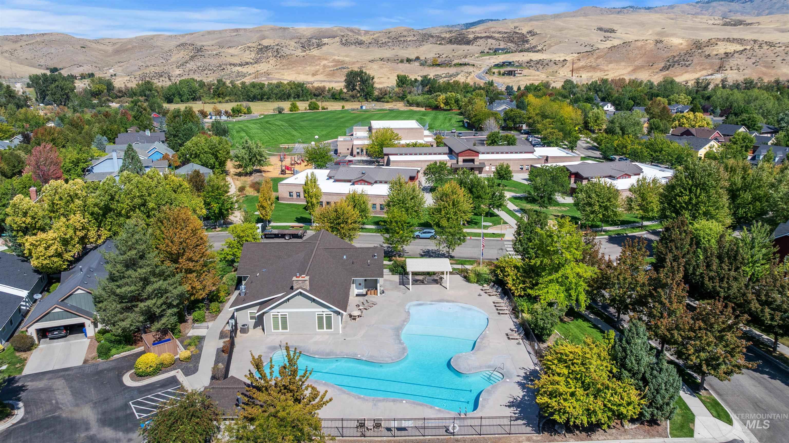 Aerial perspective of suburban area with mountains and a pool area
