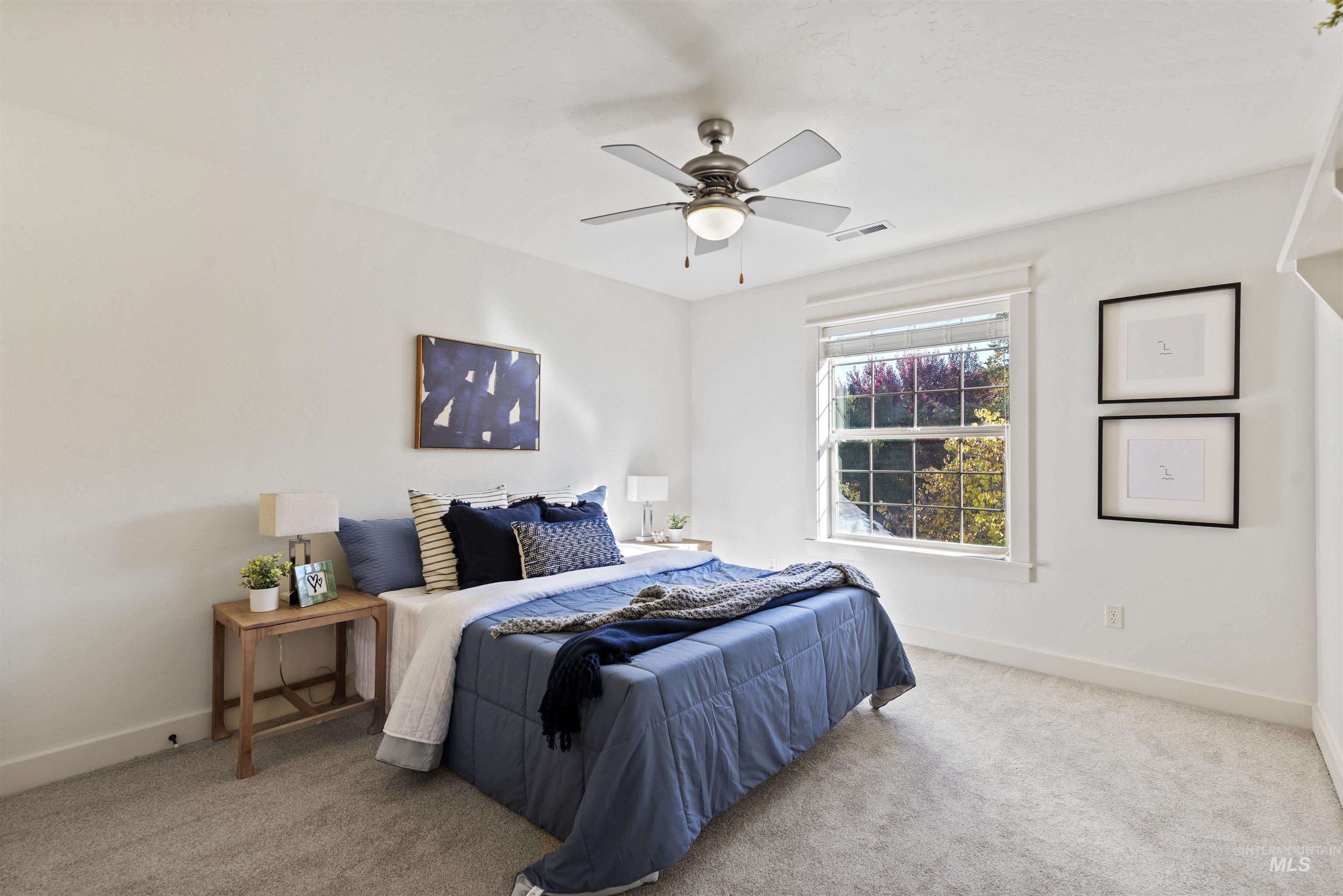 Bedroom with light carpet and a ceiling fan