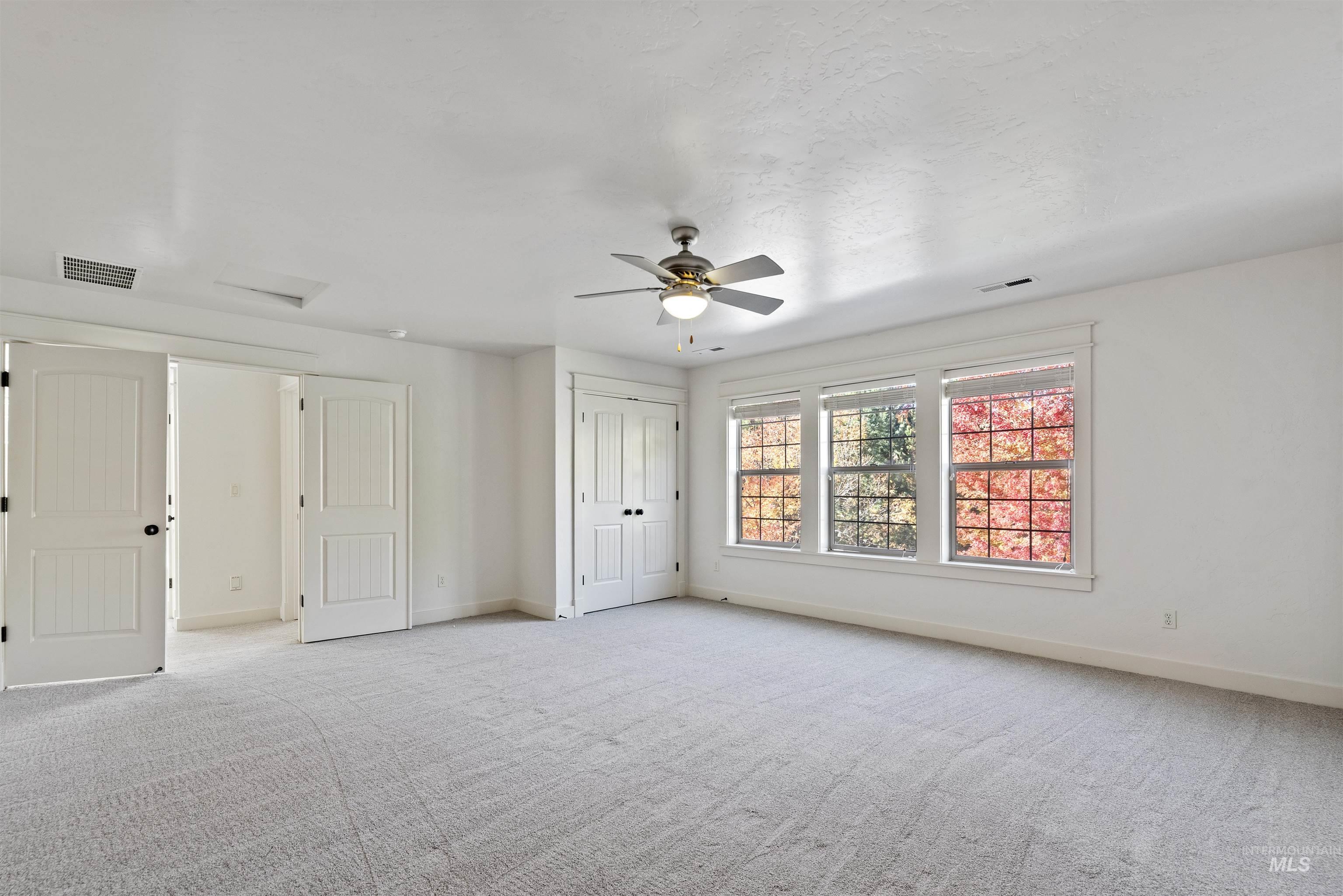 Unfurnished room with light carpet and a ceiling fan