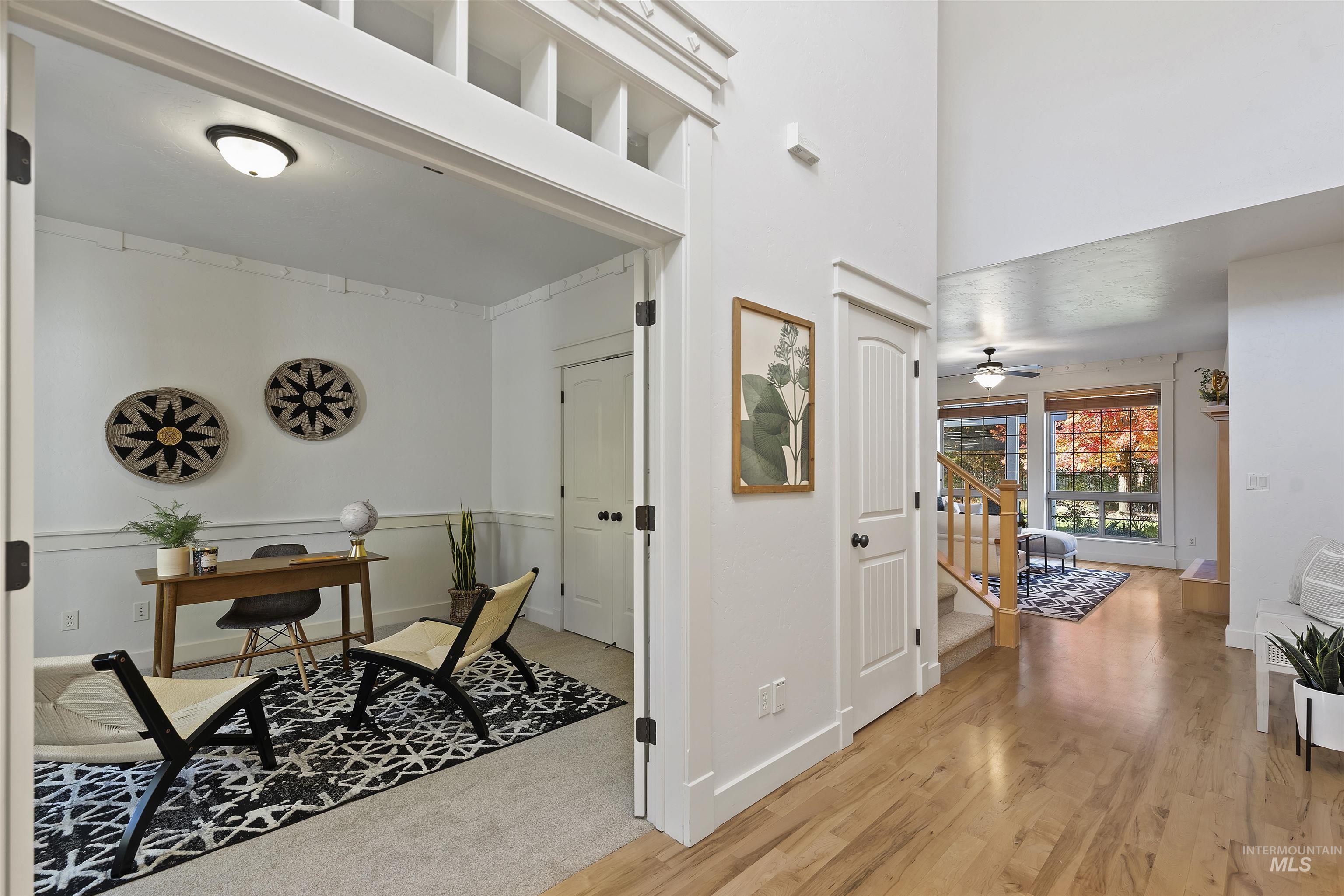 Entrance foyer with light wood-style floors, a high ceiling, stairs, and ceiling fan