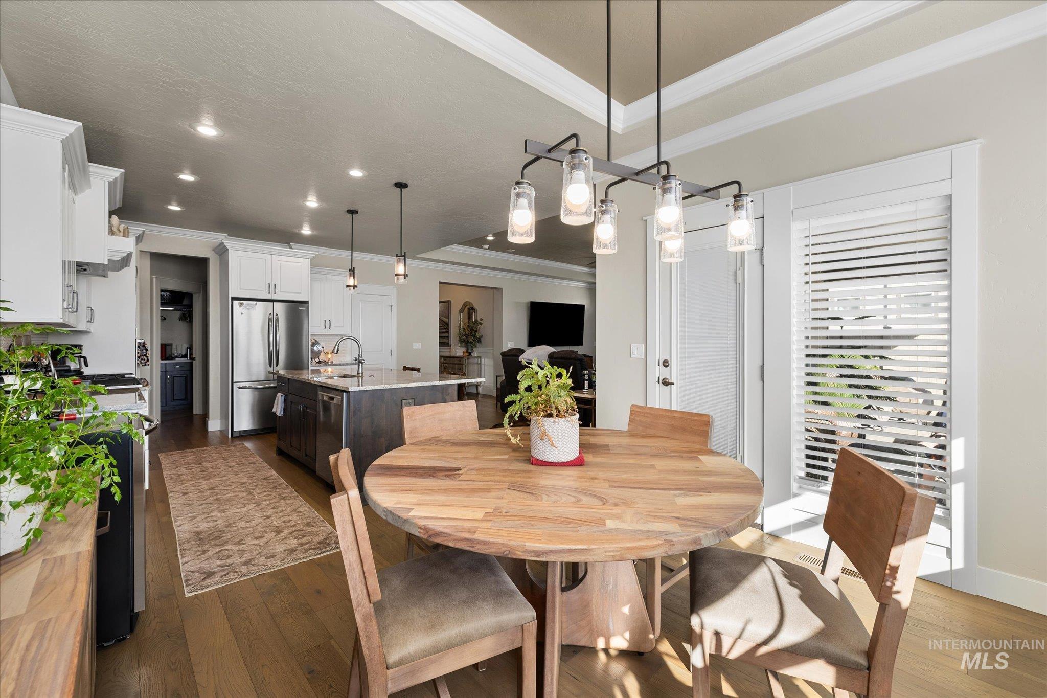 Dining area featuring ornamental molding, dark wood-style floors, and recessed lighting