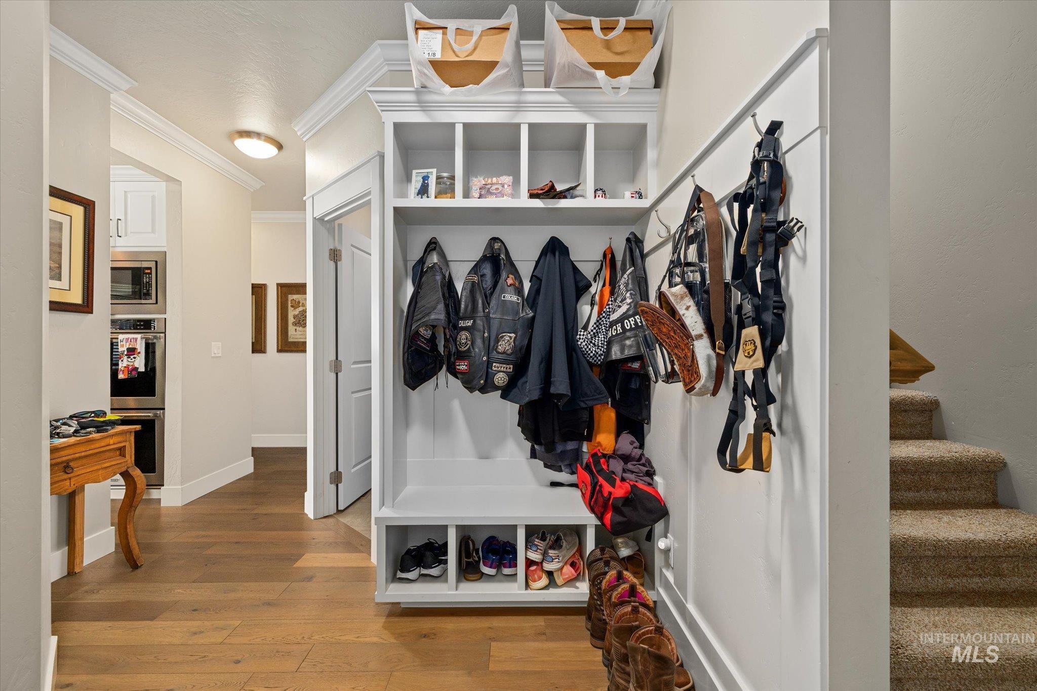 Mudroom featuring wood finished floors and ornamental molding