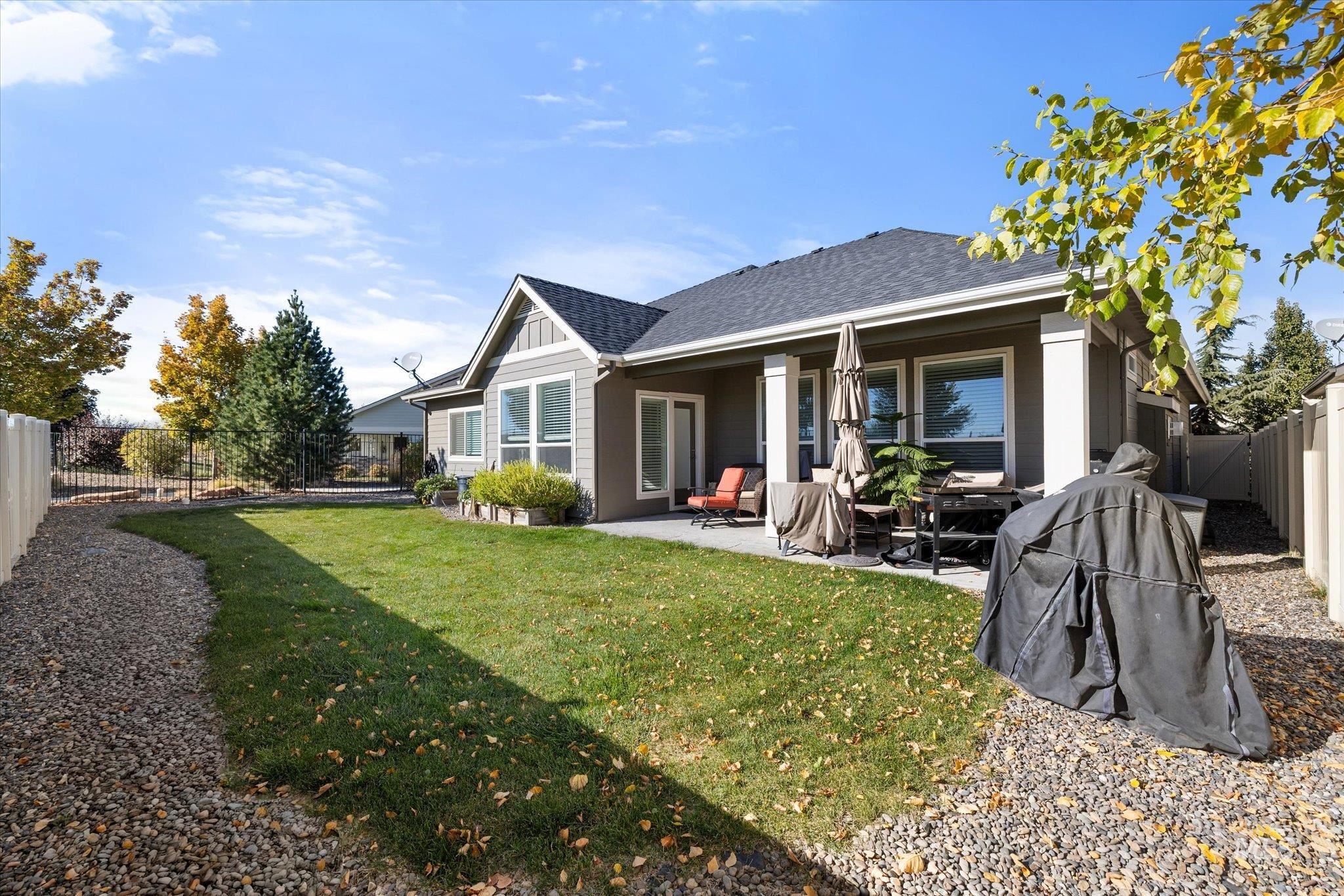 Back of property featuring a fenced backyard, a patio, and roof with shingles