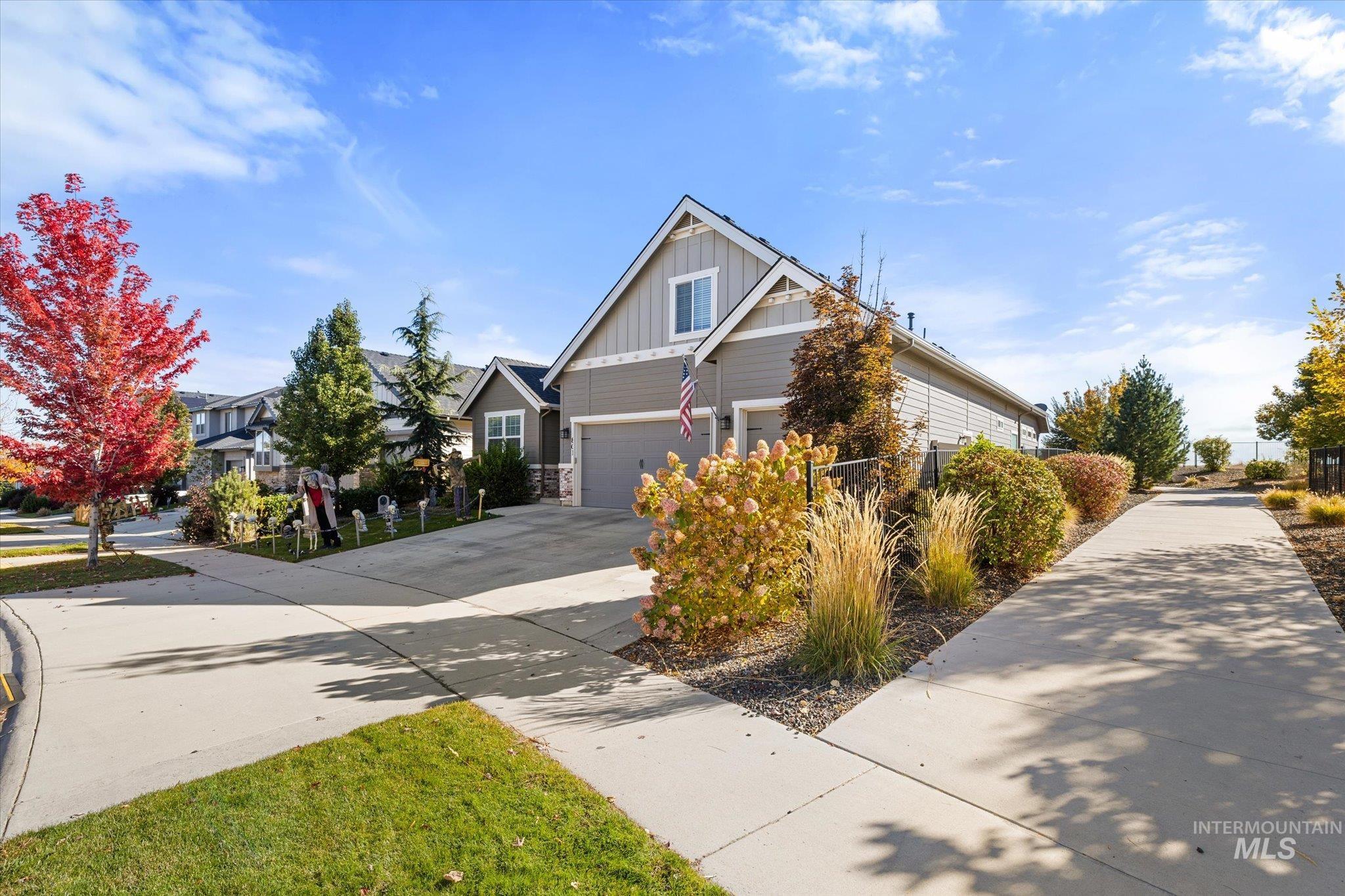 View of front of home featuring board and batten siding, concrete driveway, and a residential view