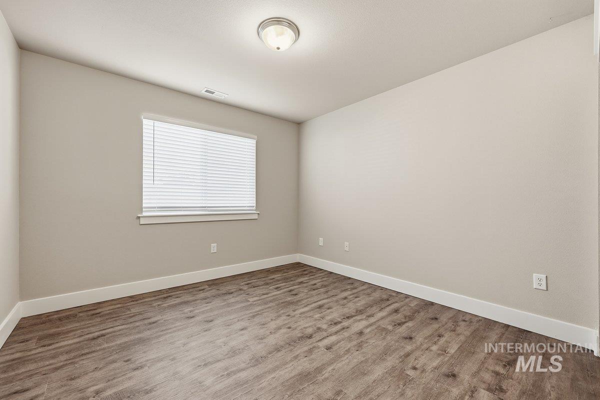 Empty room with baseboards and wood finished floors