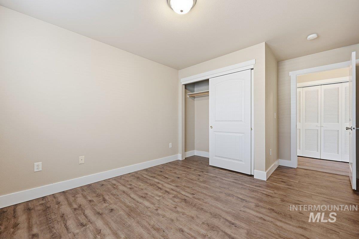 Unfurnished bedroom featuring wood finished floors and a closet