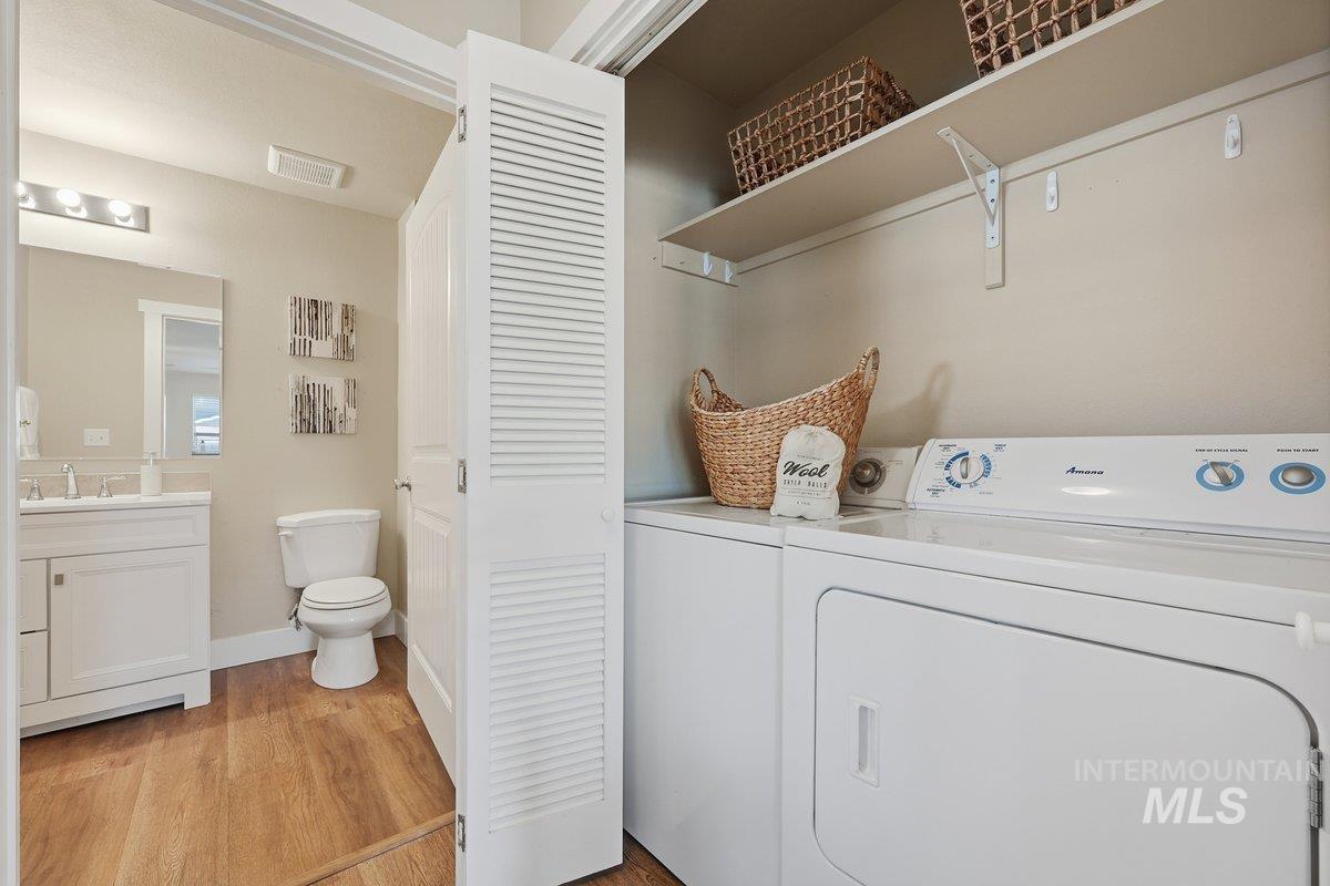 Washroom with light wood-type flooring and washer and dryer