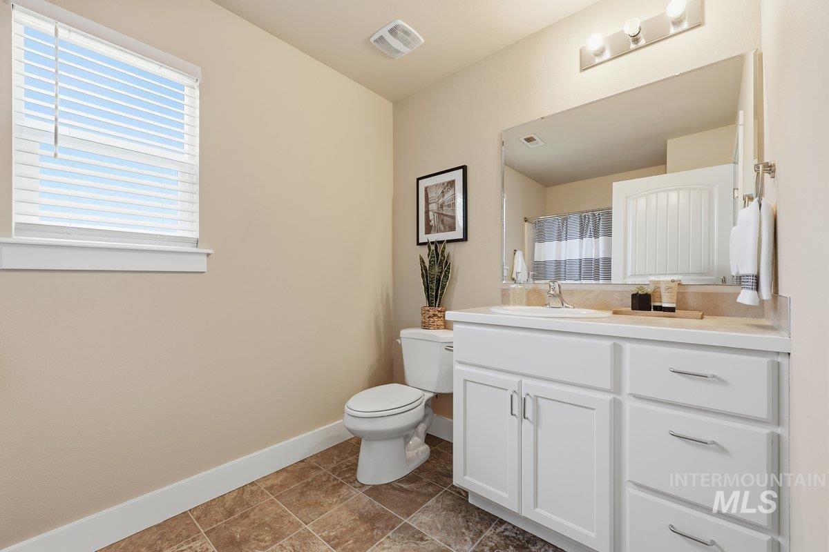 Full bath with curtained shower and vanity