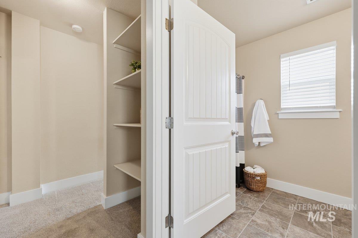 Bathroom featuring a walk in closet and a heating unit