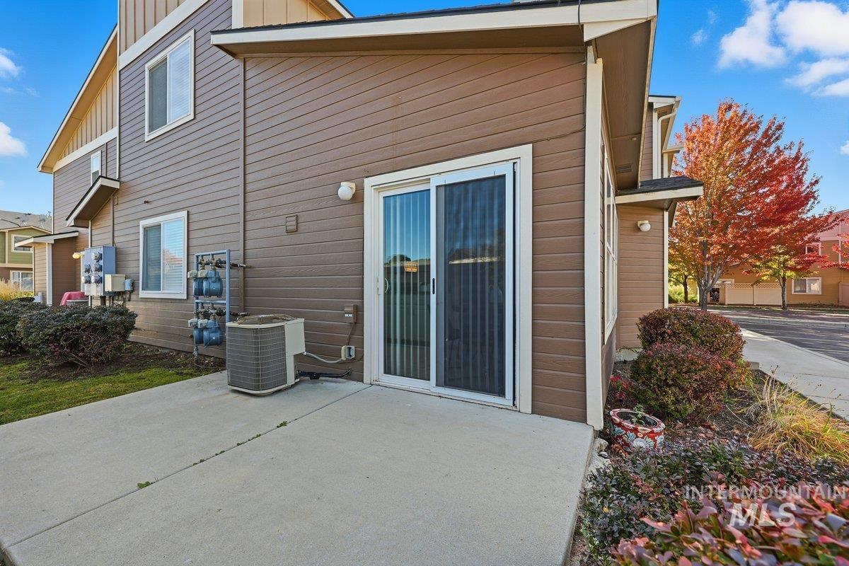 Back of property with board and batten siding and a patio