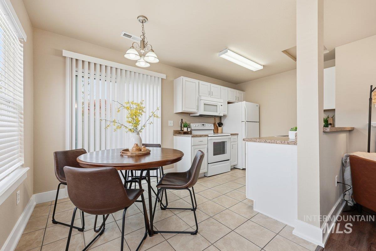 Dining room featuring light tile patterned flooring and a chandelier