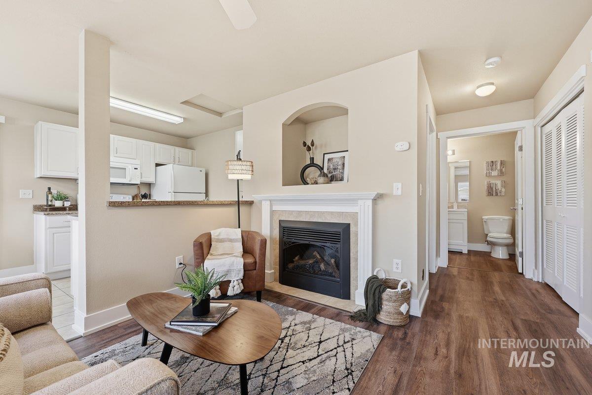 Living area with a tile fireplace and dark wood-type flooring