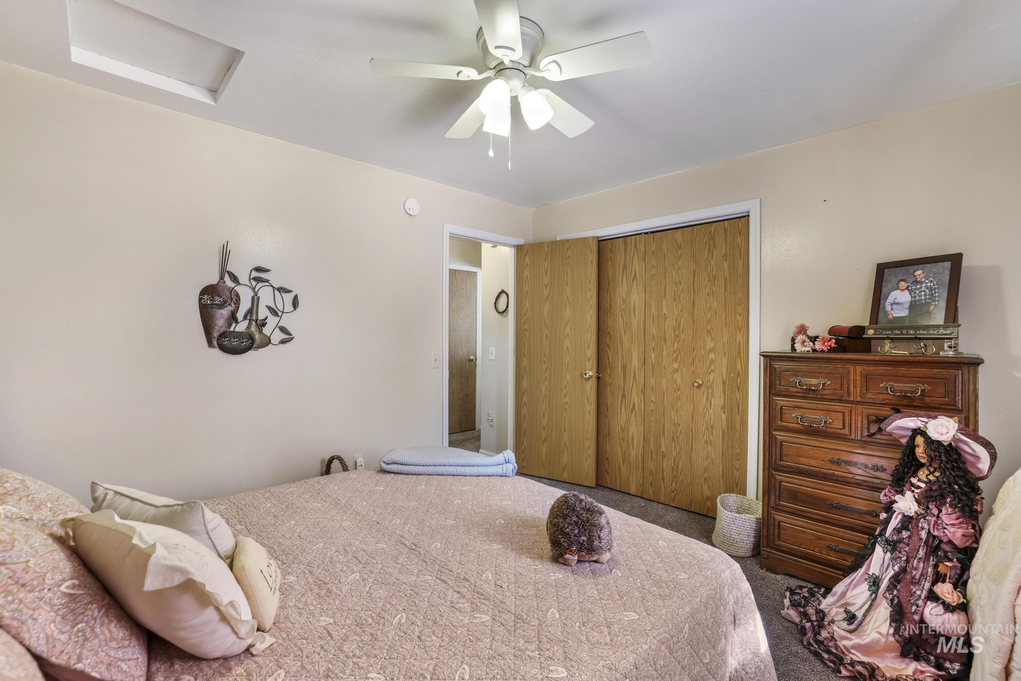 Carpeted bedroom with attic access, a closet, and ceiling fan