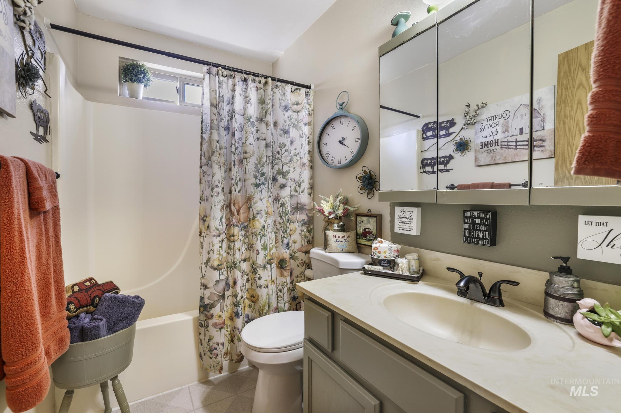 Full bathroom with shower / bath combo with shower curtain, vanity, and light tile patterned flooring