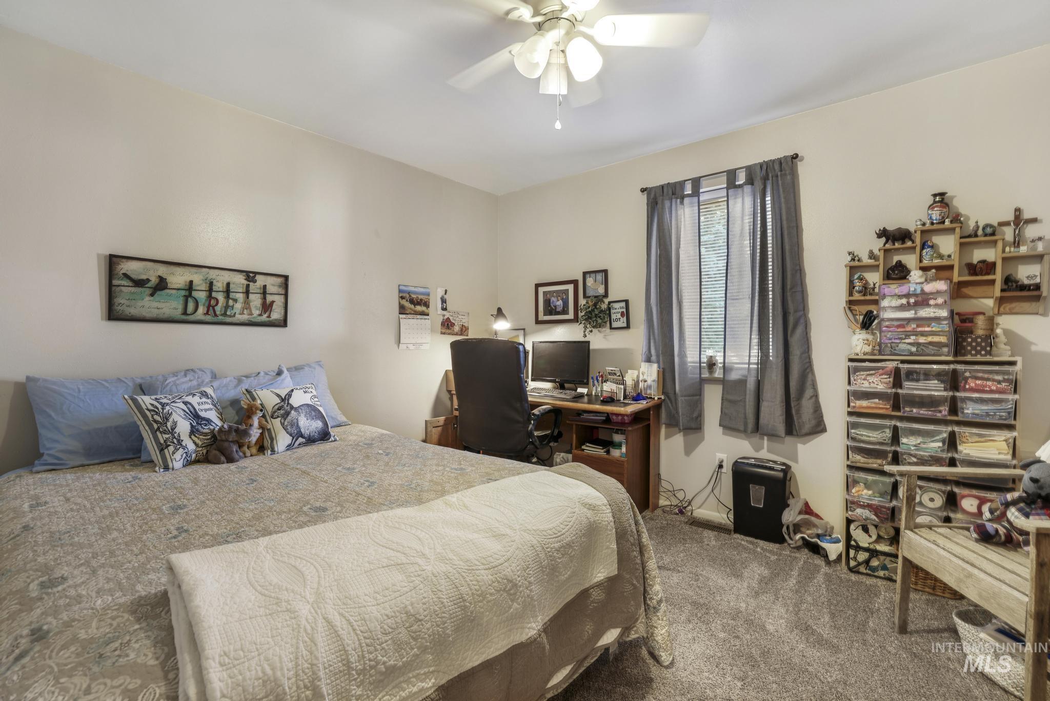 Bedroom featuring carpet flooring, an office area, and a ceiling fan
