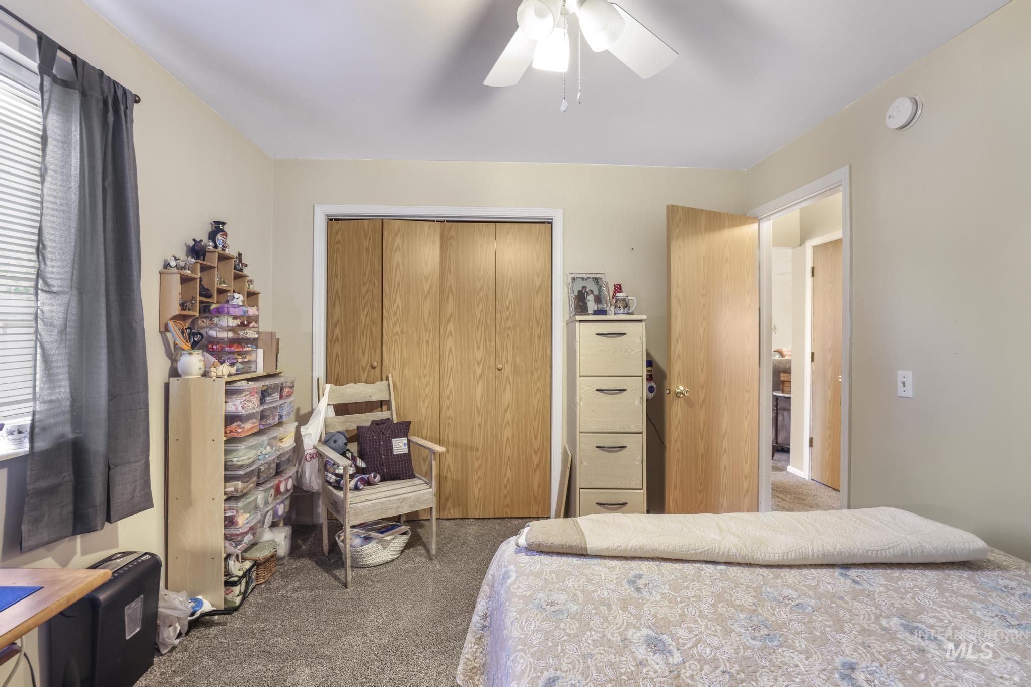 Carpeted bedroom with a closet and a ceiling fan