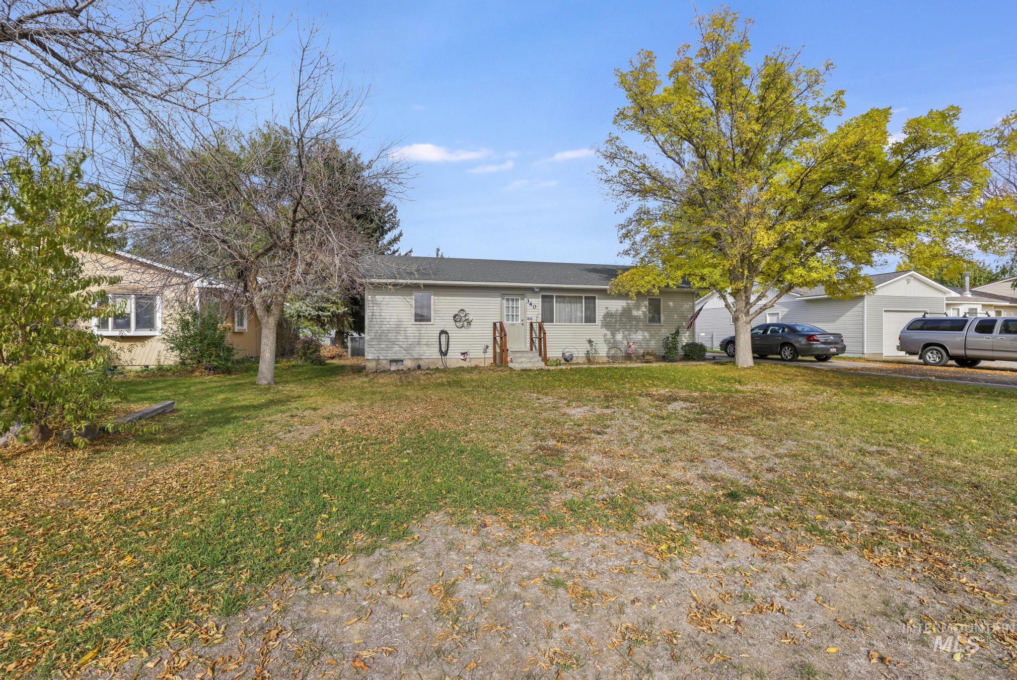 View of front of property featuring a front lawn, crawl space, and a garage