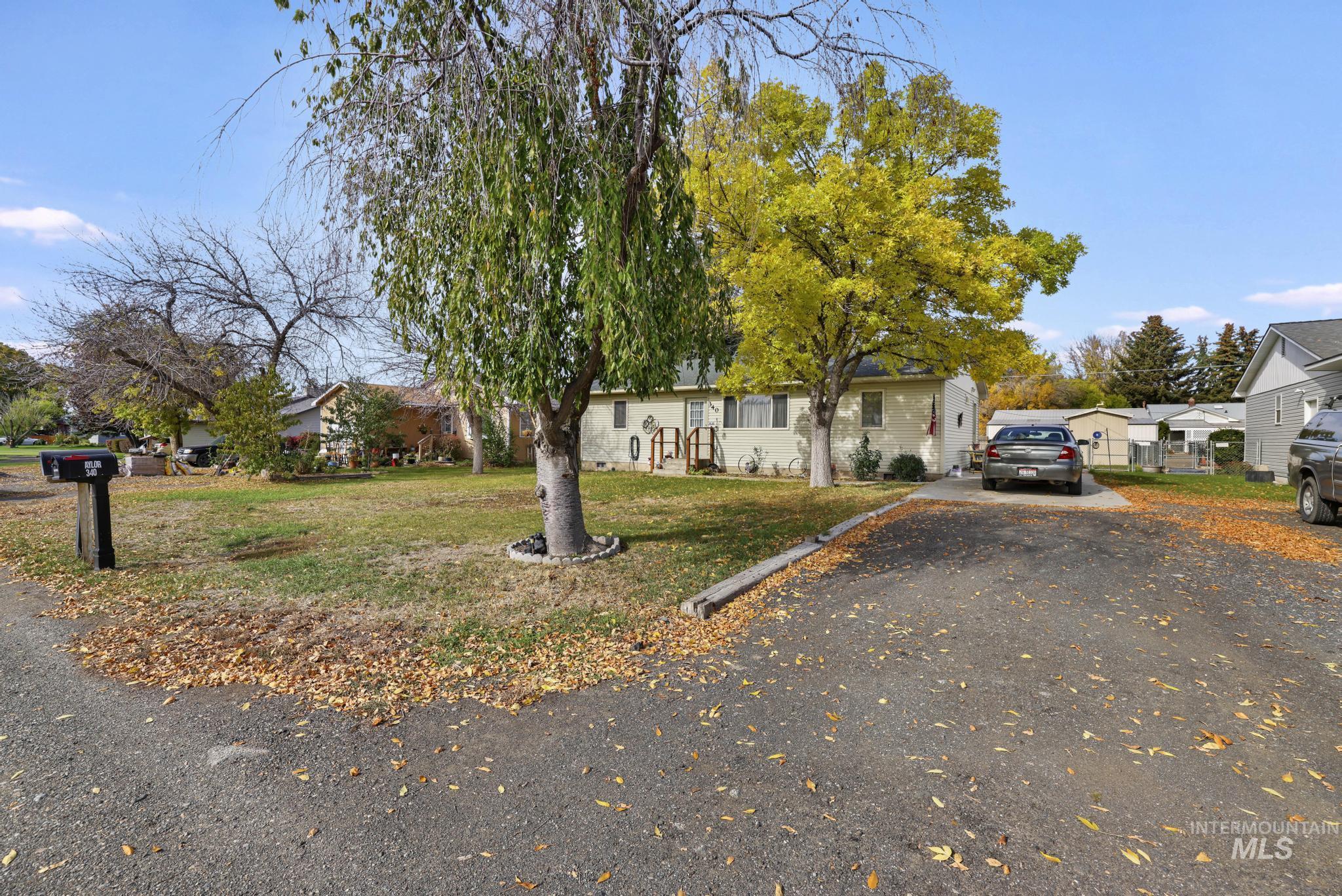 View of front facade with asphalt driveway, a front yard, and a residential view