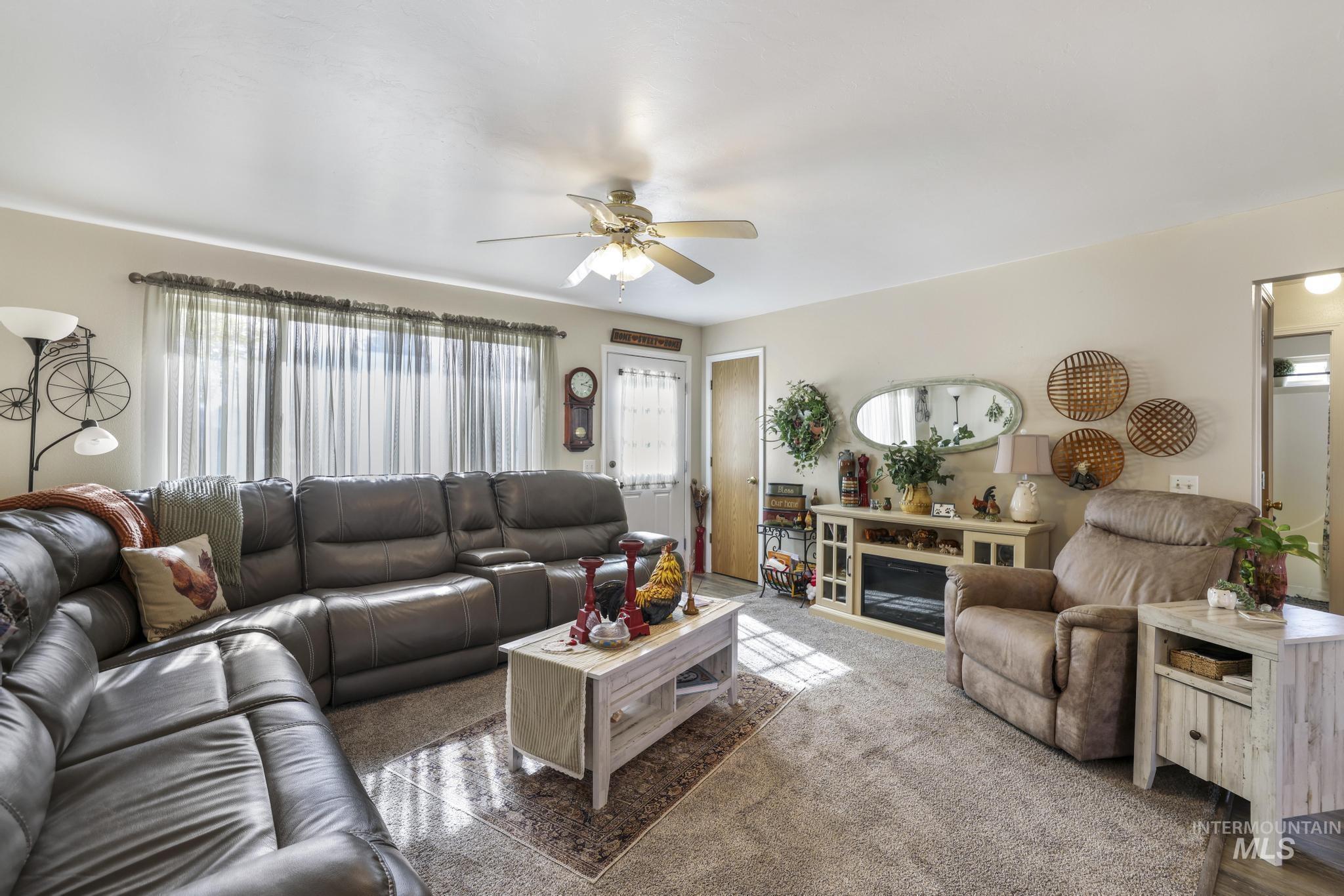 Living room featuring ceiling fan and carpet