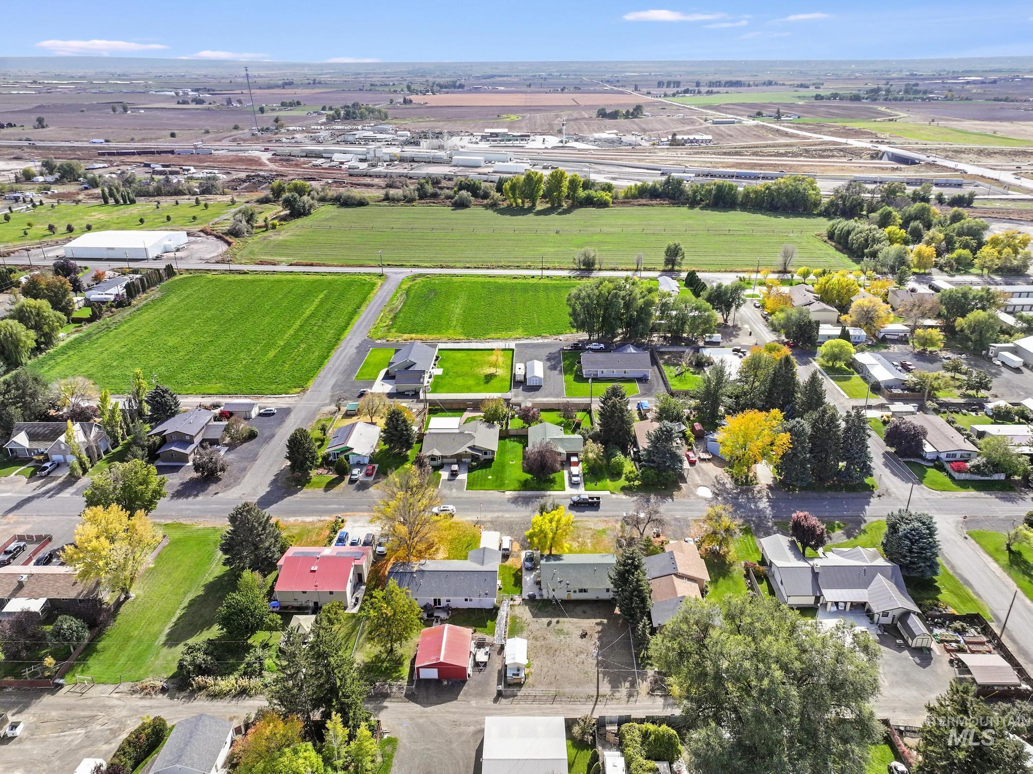 Aerial view of property and surrounding area featuring nearby suburban area