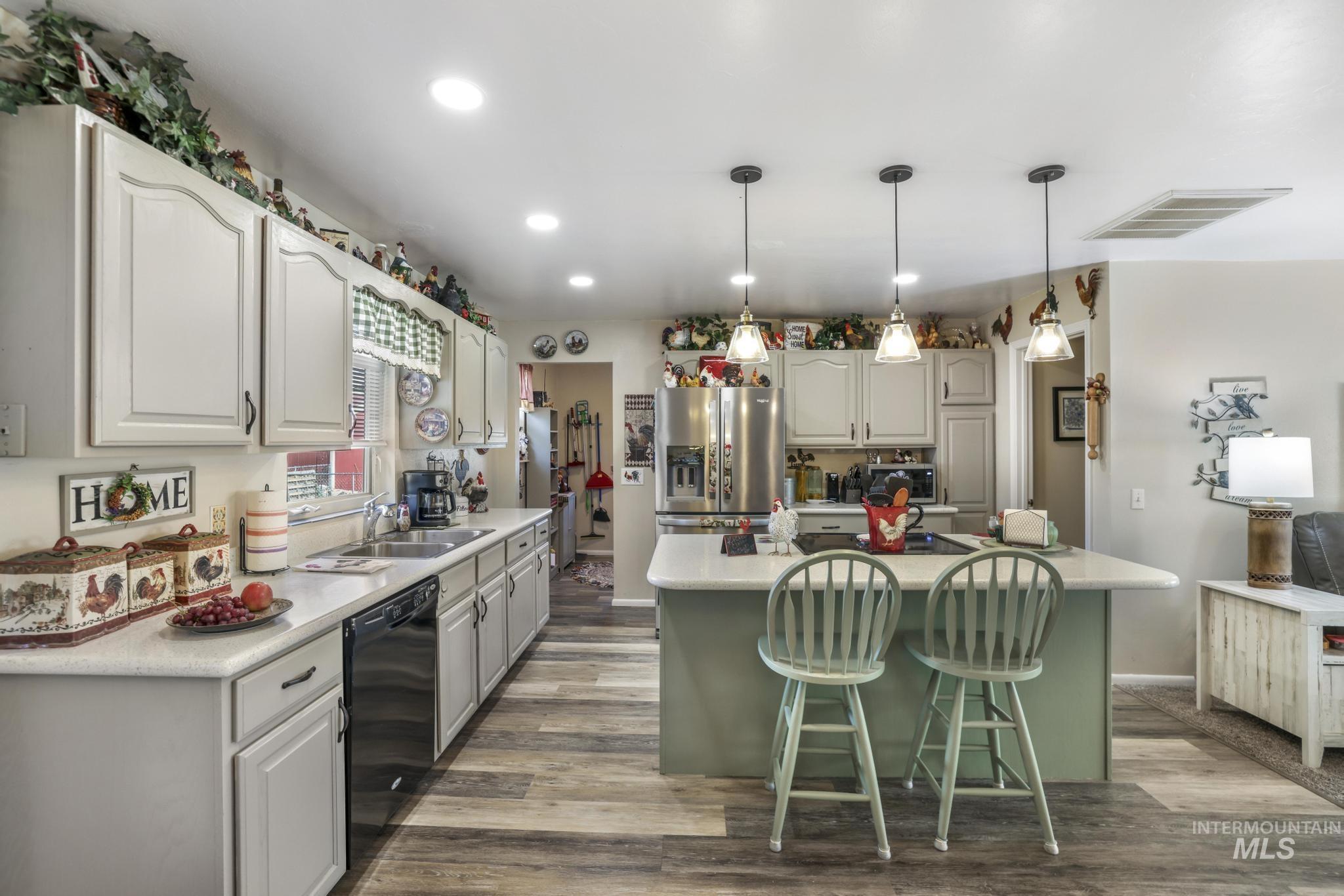 Kitchen with pendant lighting, dark wood-style flooring, a center island, stainless steel appliances, and recessed lighting