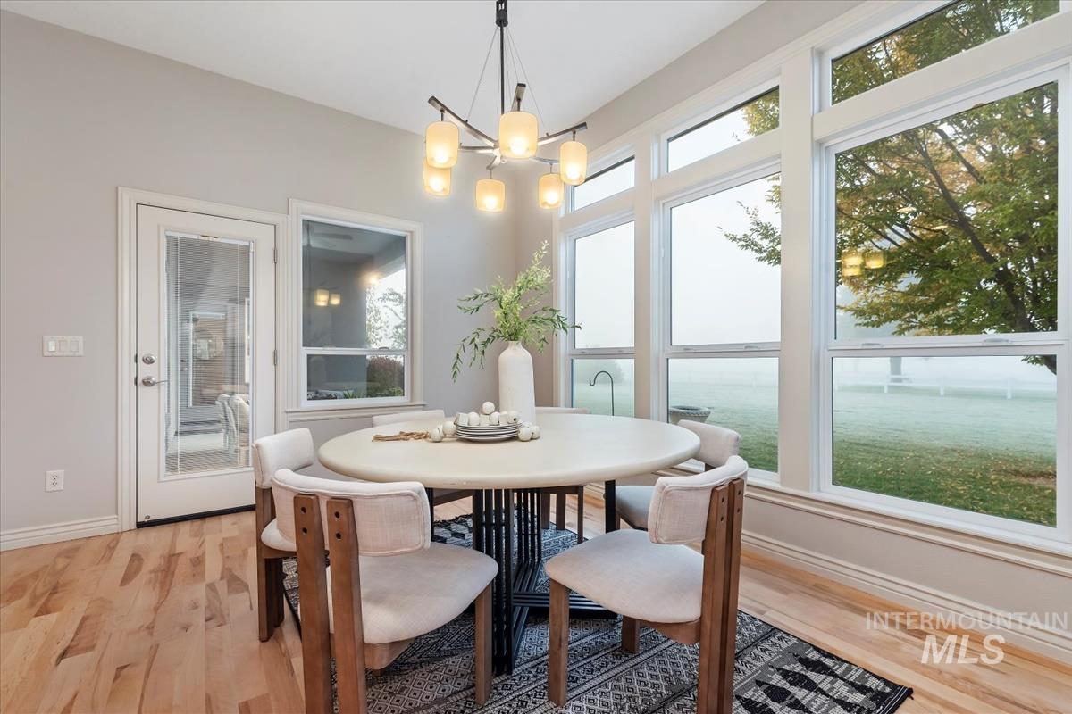 Dining space with healthy amount of natural light, light wood-style flooring, and a chandelier