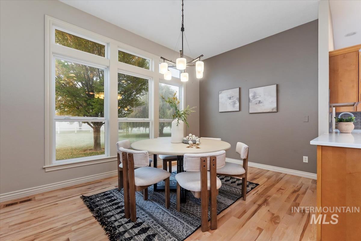 Dining space with light wood finished floors and a chandelier