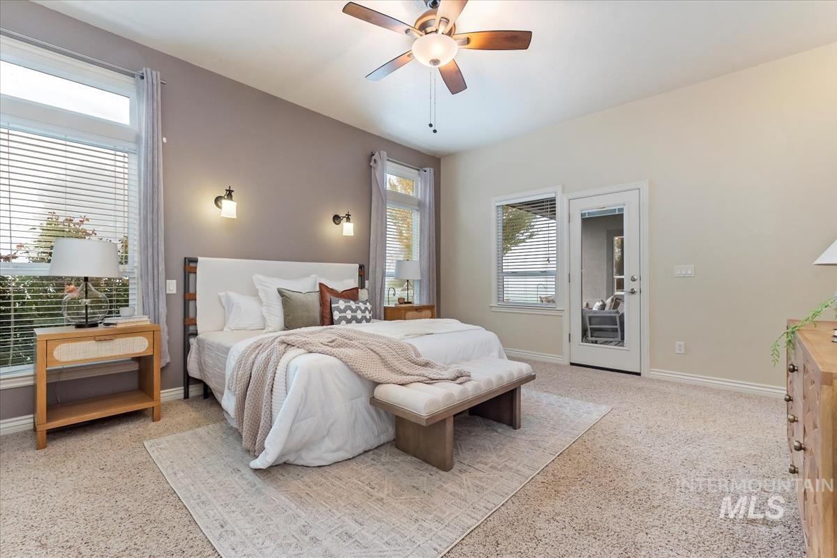 Bedroom with ceiling fan, light colored carpet, and access to outside