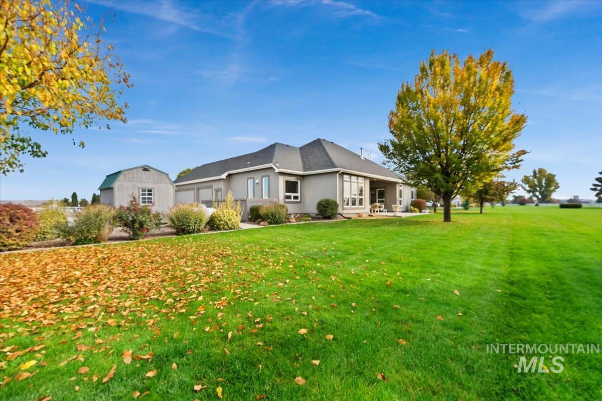 View of home's exterior featuring a lawn, stucco siding, and an outbuilding