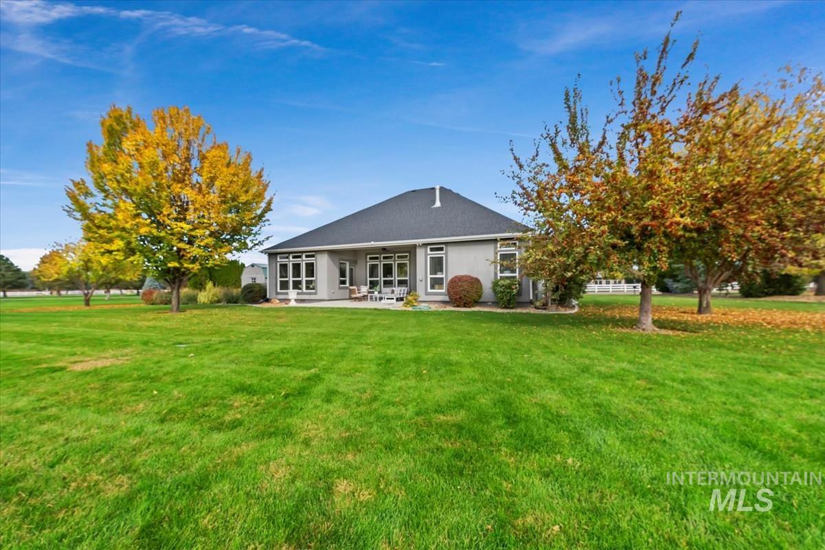 Rear view of property with a yard and a patio