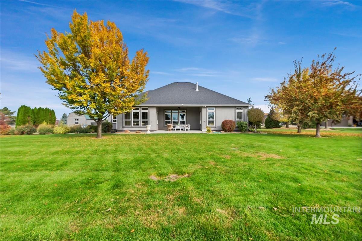 Rear view of property with a yard and a patio