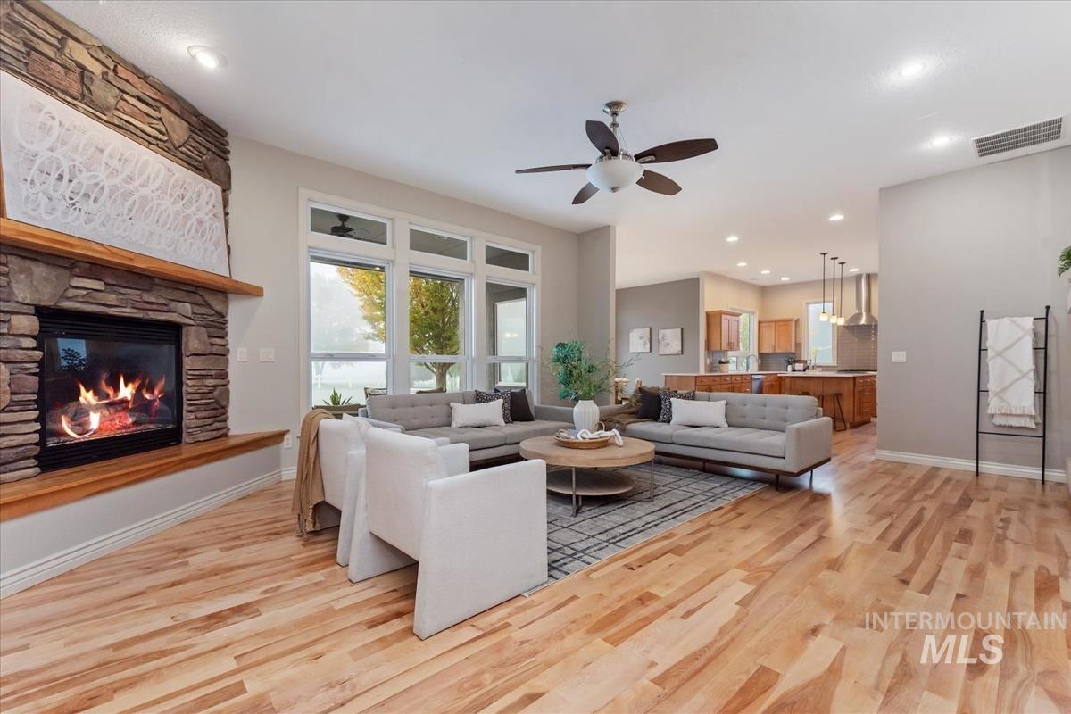 Living area featuring recessed lighting, ceiling fan, light wood-type flooring, and a fireplace