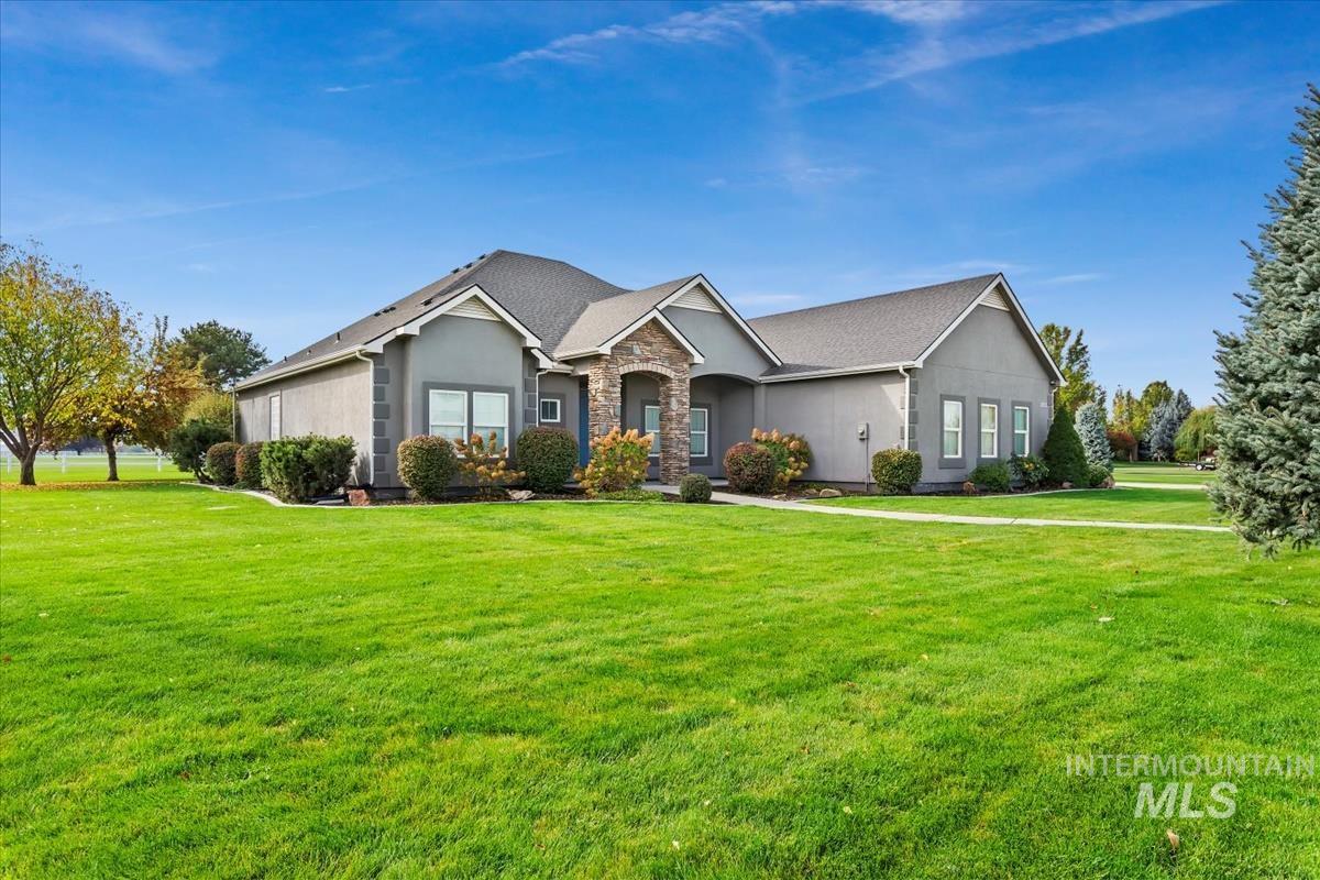 View of front of home with a front lawn, stone siding, and stucco siding