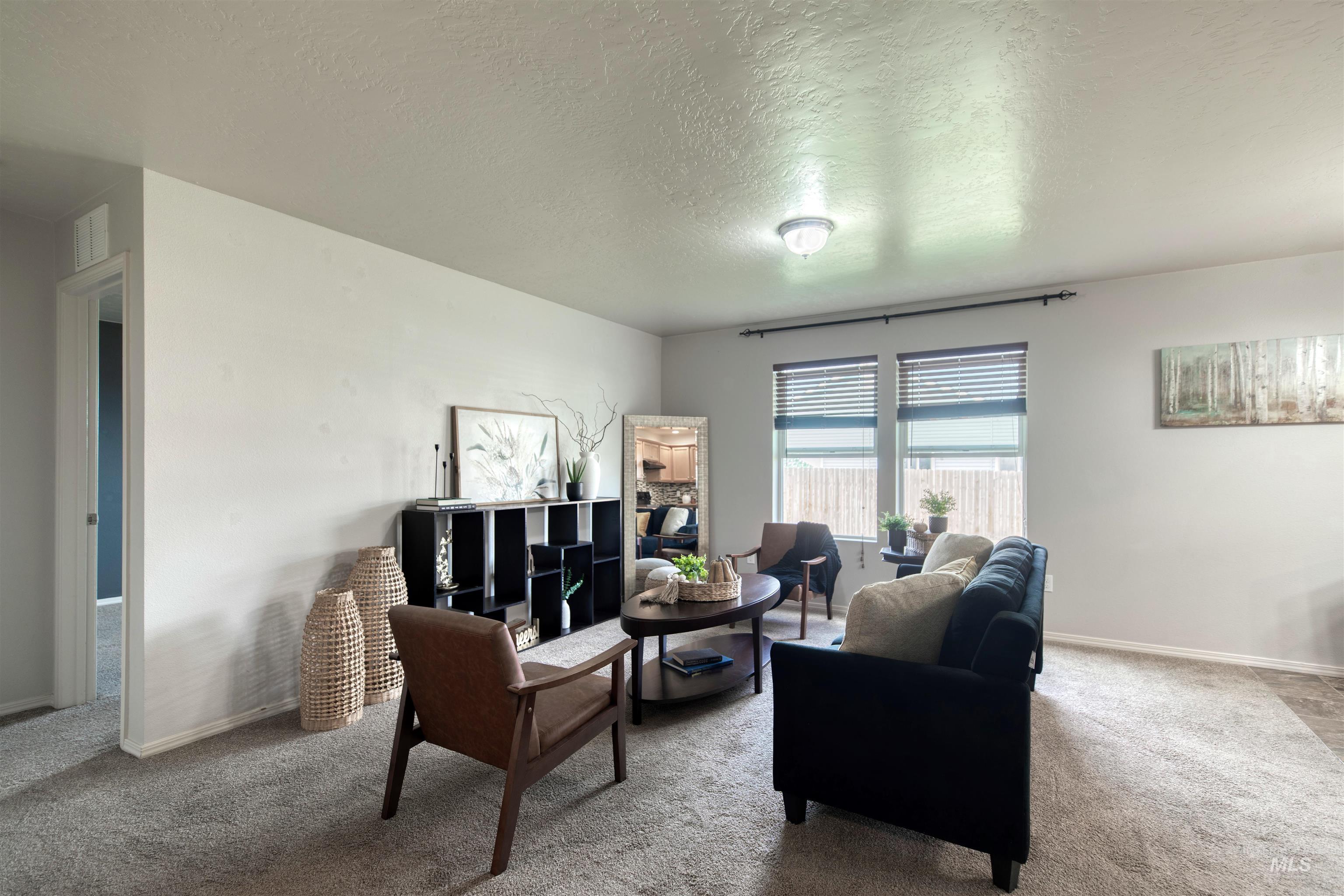 Living area featuring carpet flooring and a textured ceiling